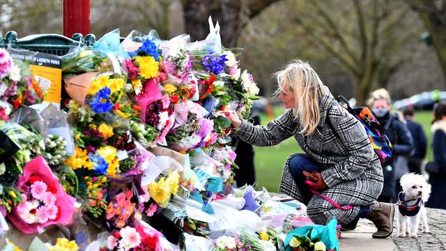 A well-wisher places flowers at a bandstand