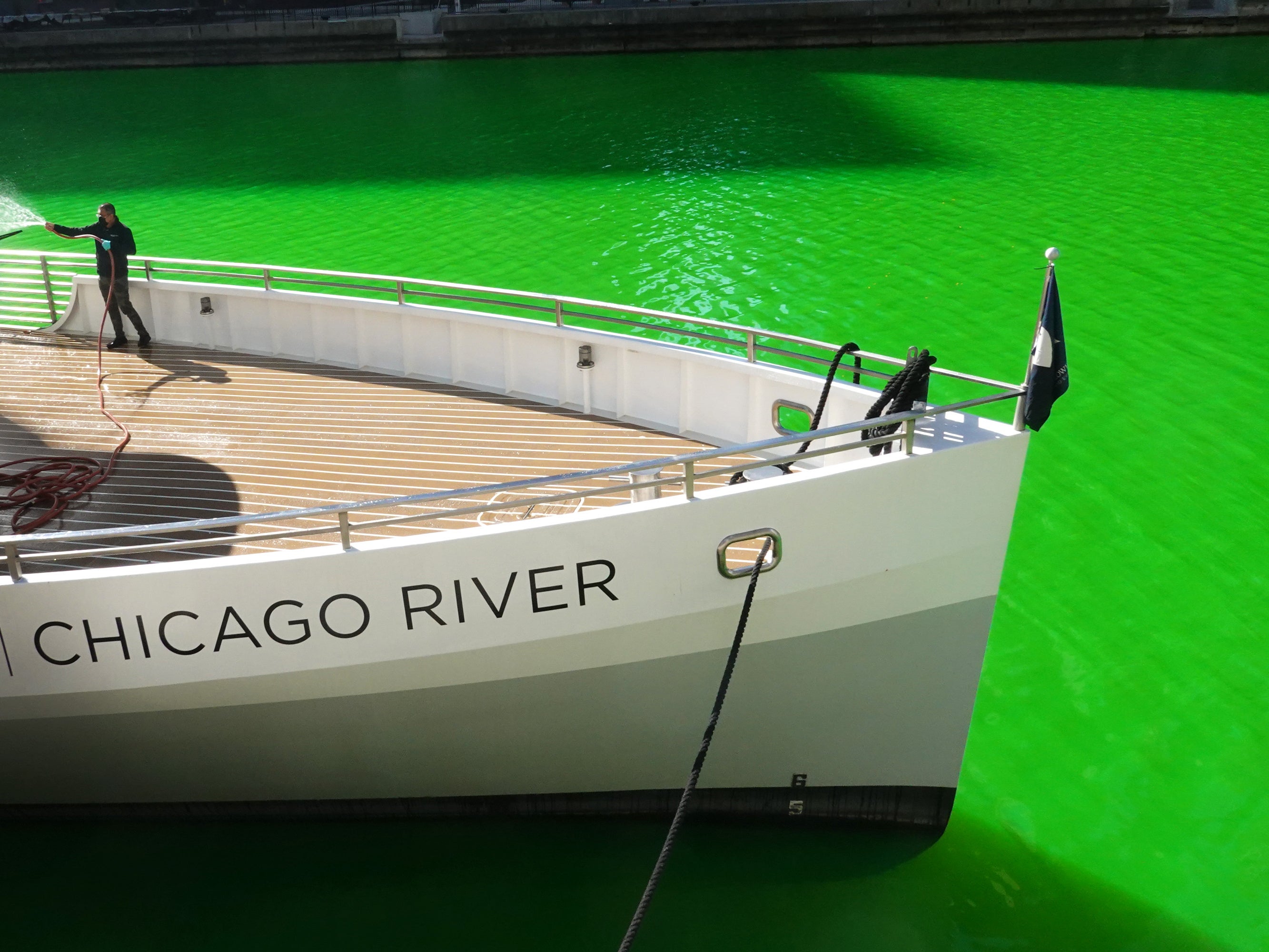 A worker cleans a boat in the Chicago River after it was dyed green in celebration of St Patrick’s Day on 13 March 2021 in Chicago, Illinois