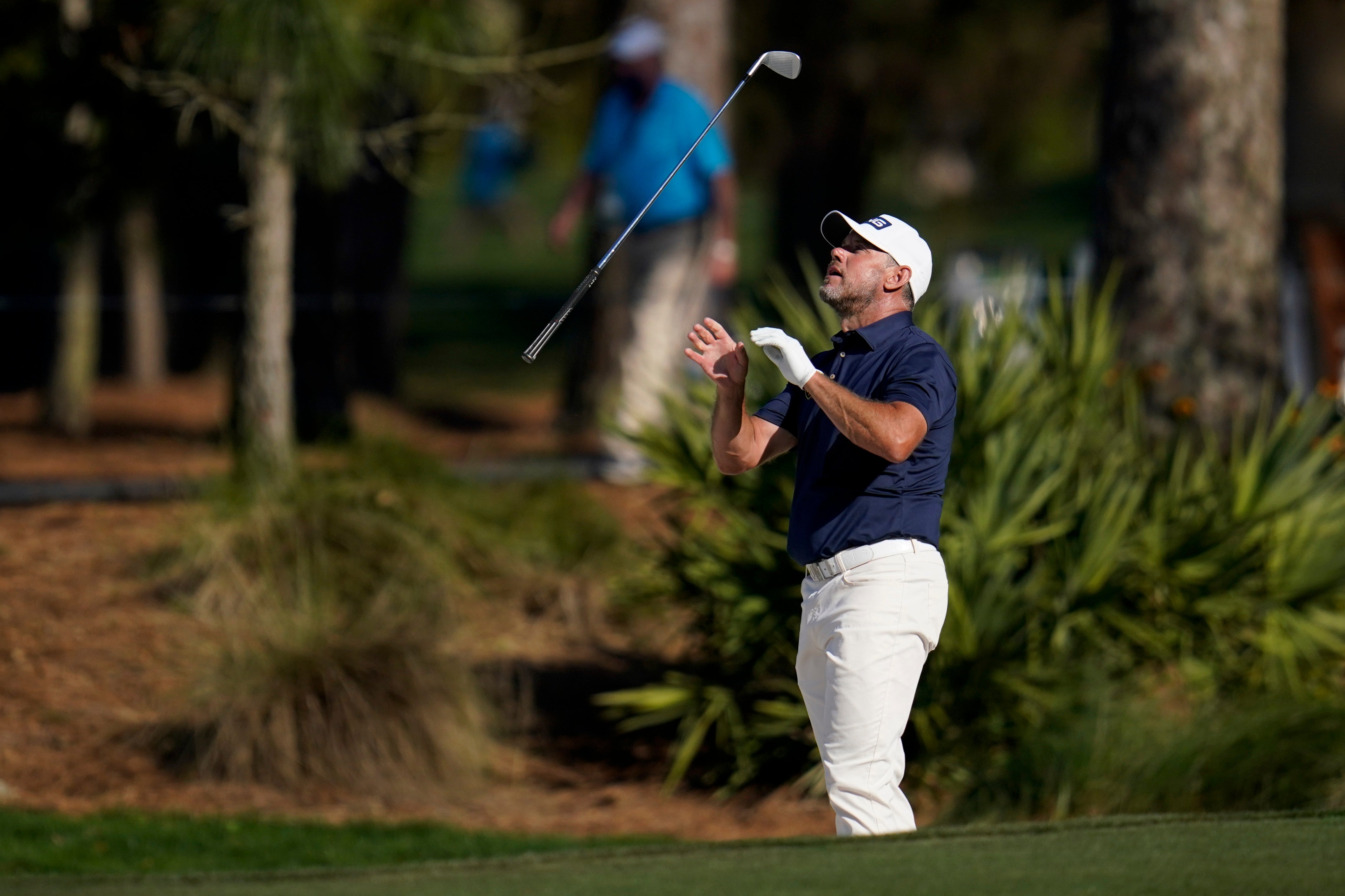 Lee Westwood tosses his club after a bunker shot at the 15th