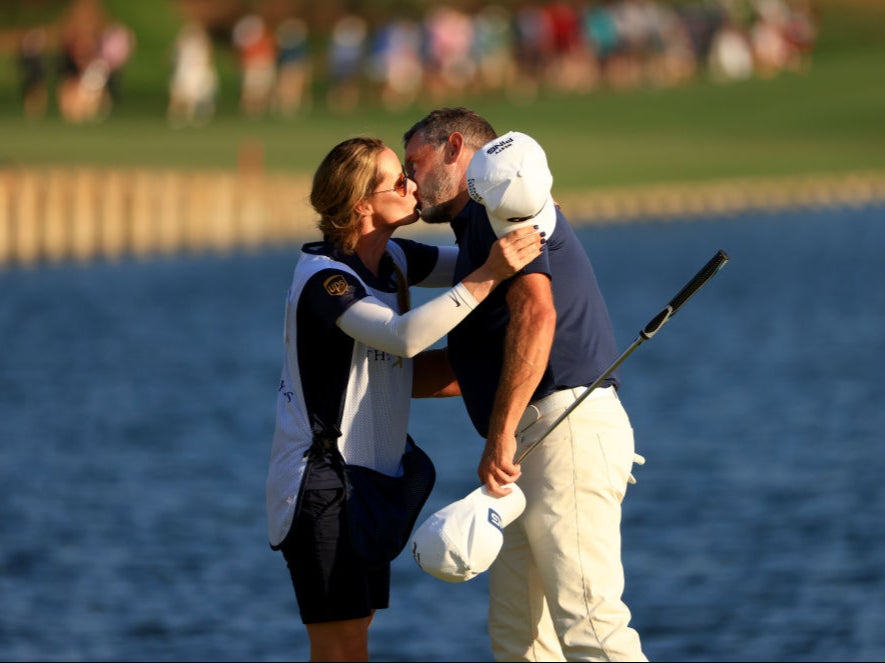 Lee Westwood kisses his fiance and caddie Helen Storey on the 18th green