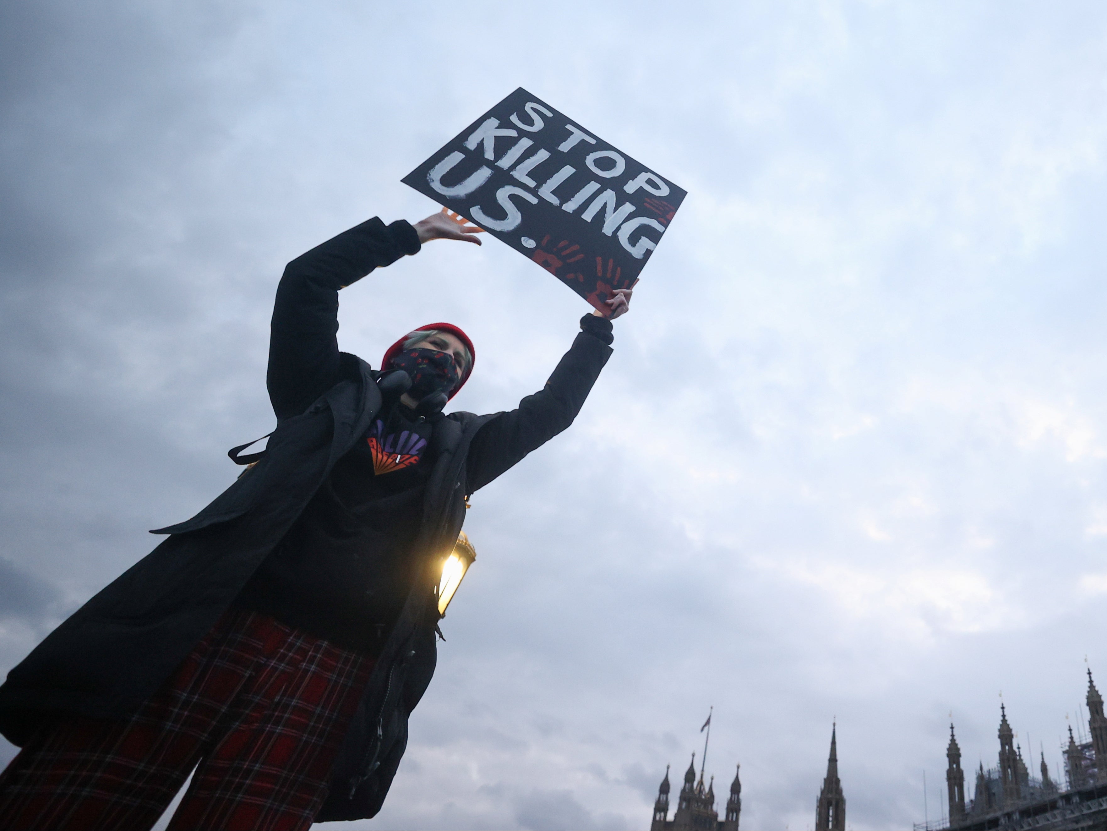 A simple but powerful sign reads "stop killing us", in response to violence against woman.
