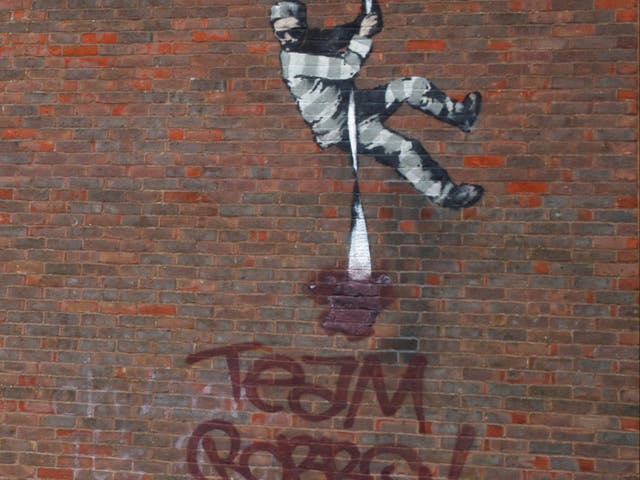 Banky’s defaced artwork on a wall at Reading prison
