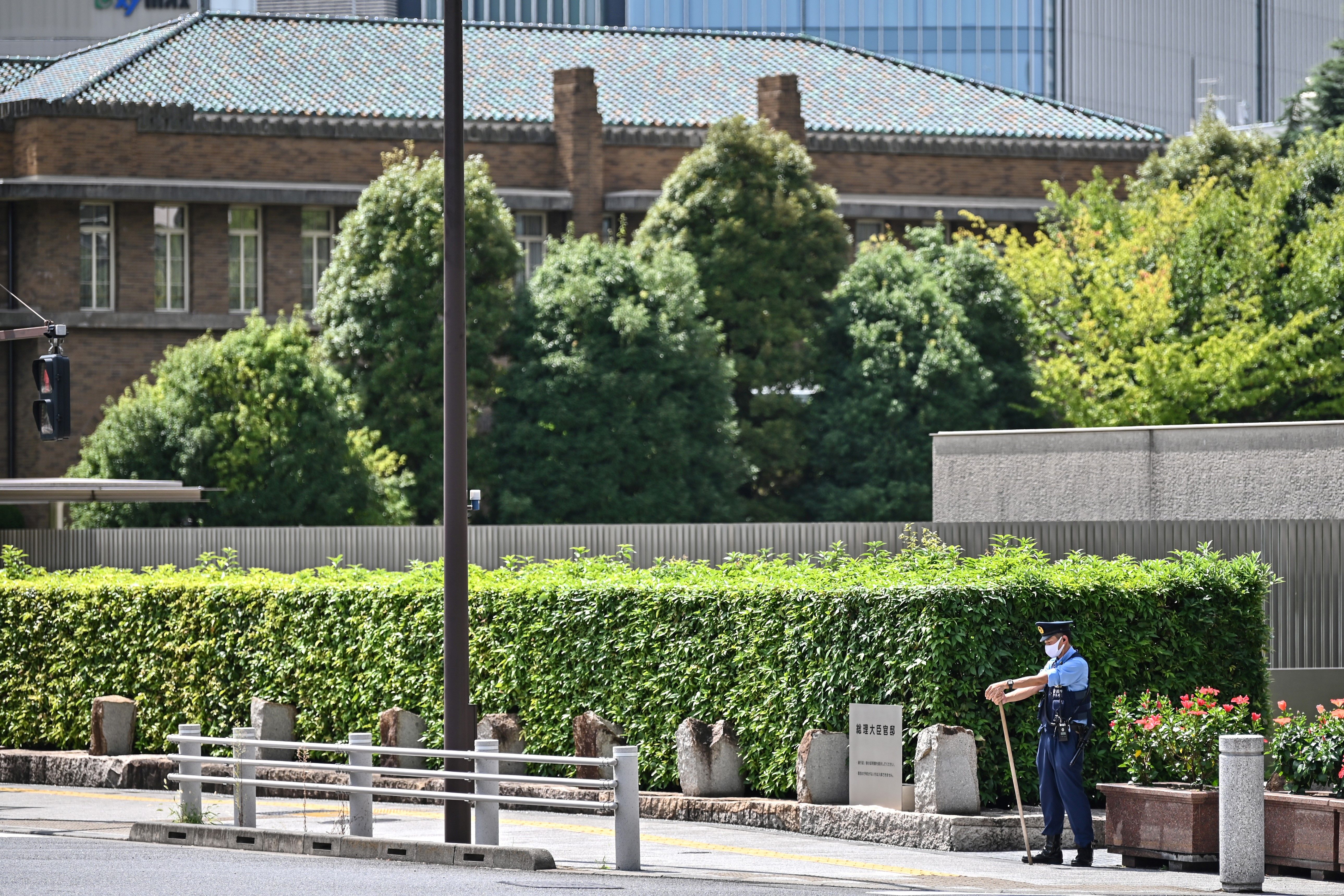 File: A policeman patrols on a road leading to the residence (background) and office of Japan’s Prime Minister in Tokyo