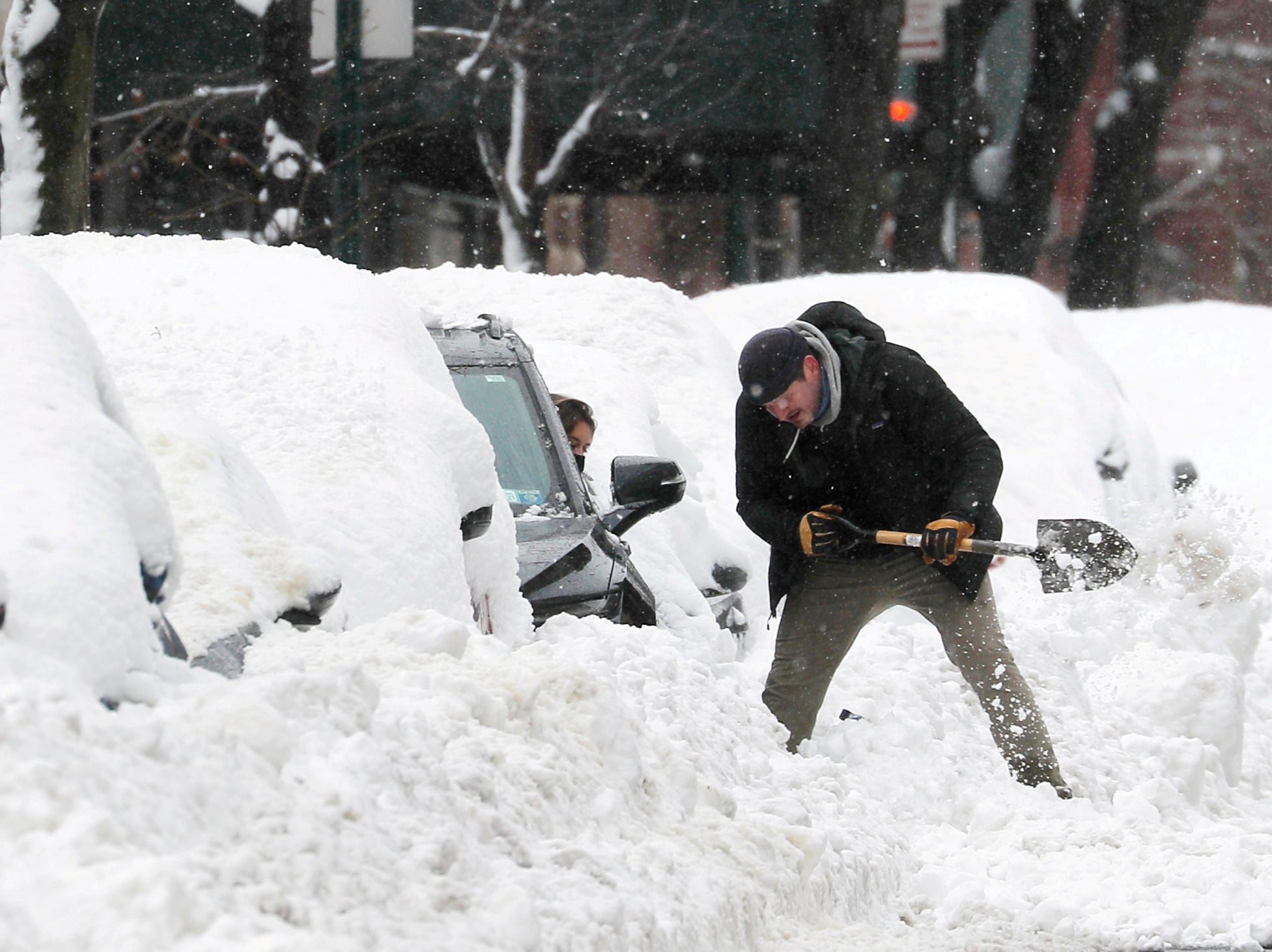<p>A man helps a driver dig her car out from deep snow on Manhattan’s upper west side after a winter storm in New York City, New York, US, 2 February, 2021</p>