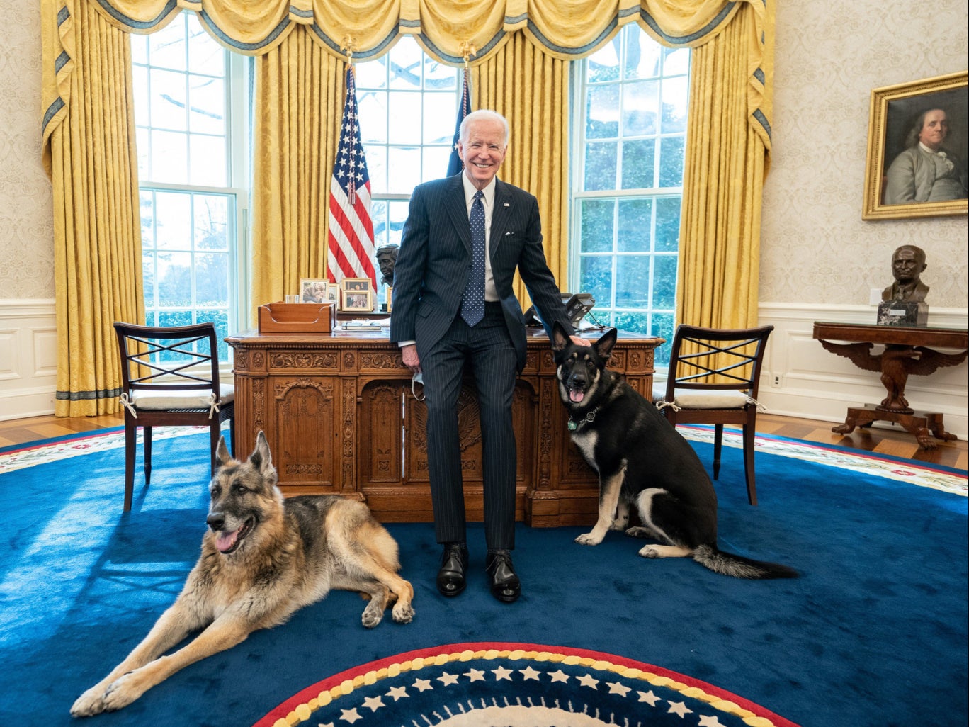 President Joe Biden poses with the Biden family dogs Champ and Major