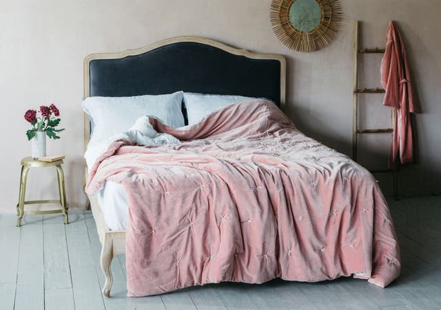 A bedroom featuring an Alora Grey Velvet Bed and Pebble Velvet King Size Quilt in Rose, from Graham & Green