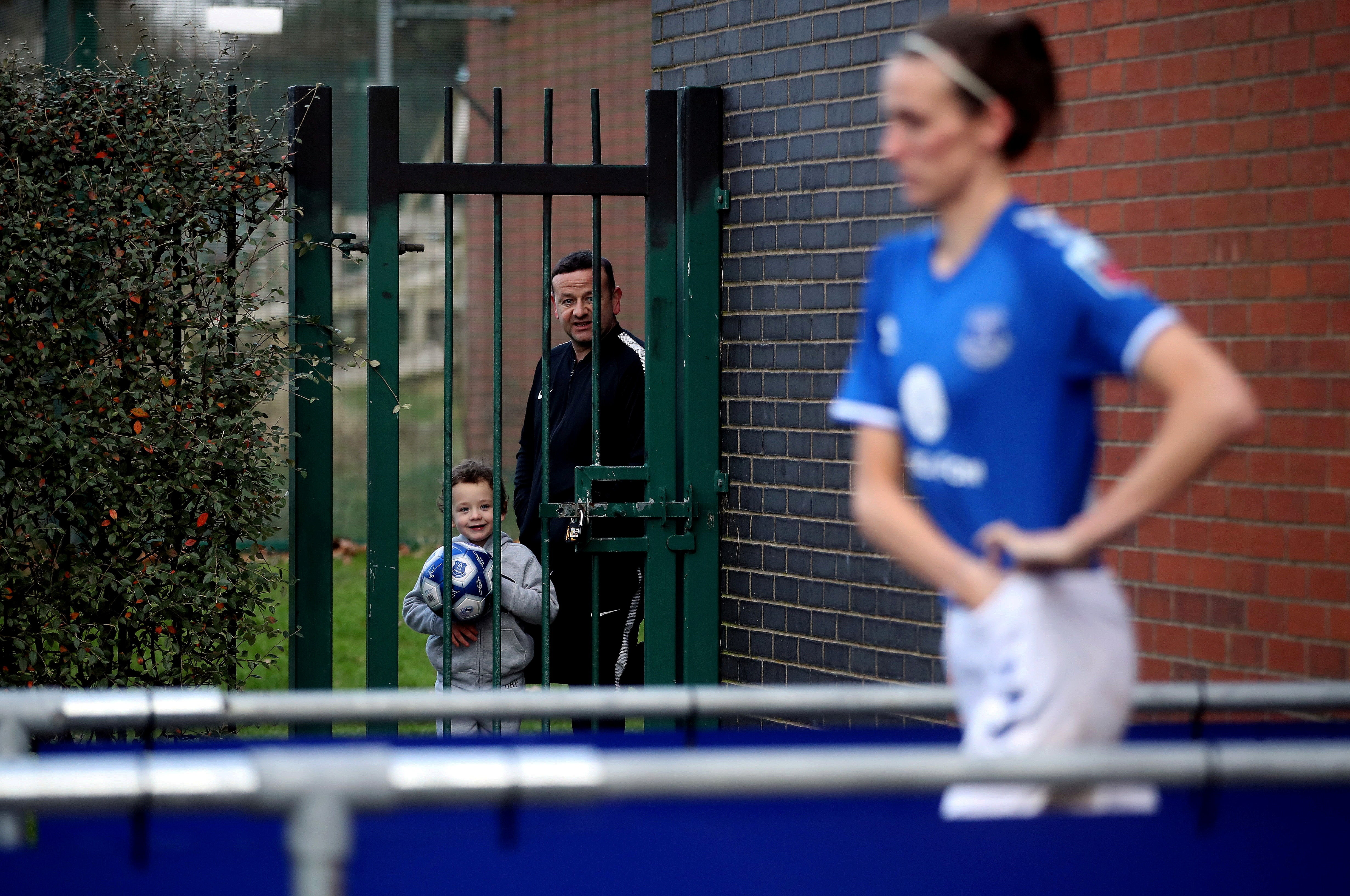 Two fans watch Toffees player Jill Scott before the Women's Super League match between Everton and Manchester United at Walton Hall Park in January.