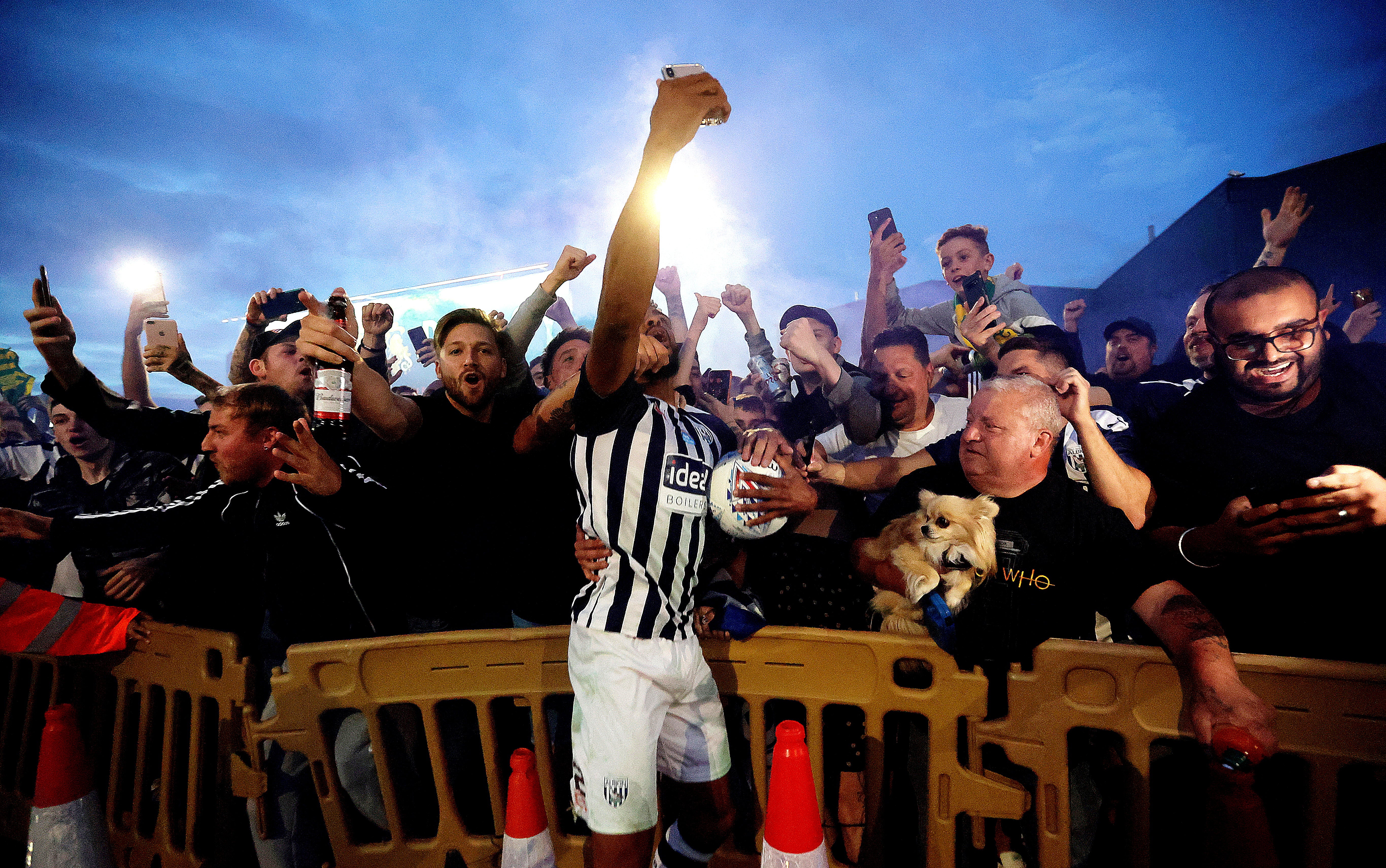 Darnell Furlong celebrates promotion with West Brom fans outside of the stadium