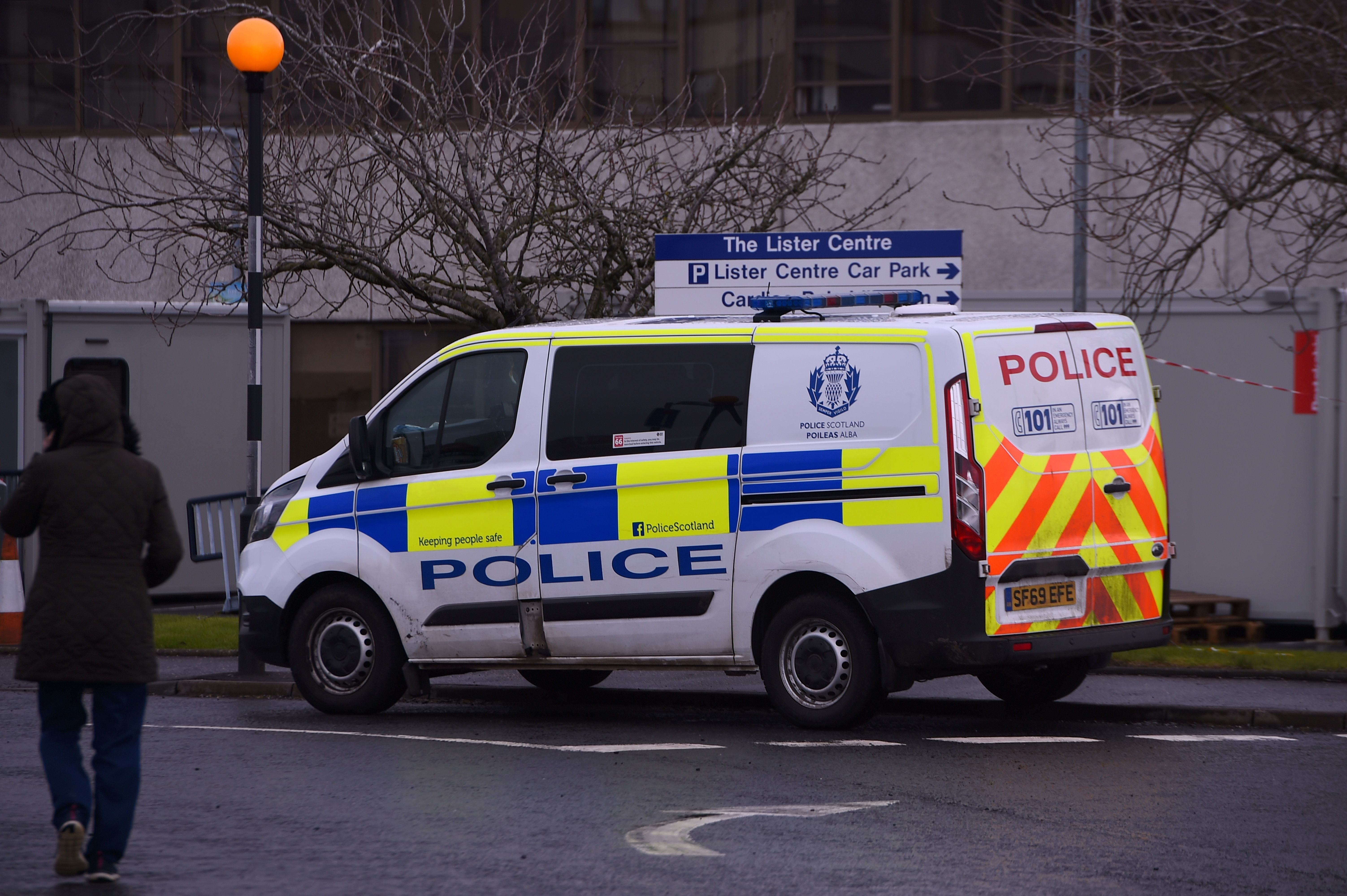 A Police vehicle is pictured at the scene of a fatal stabbing outside Crosshouse Hospital in Kilmarnock, in west Scotland, on 5 February, 2021. Police Scotland are trying to identify the body of a man found in a burn in West Lothian.