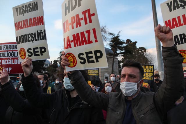People hold banners and shout slogans during a protest against moves to ban pro-Kurdish HDP in Istanbul