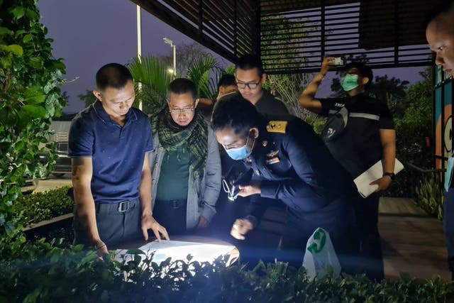 Thai authorities look at documents found during the operation against the syndicate