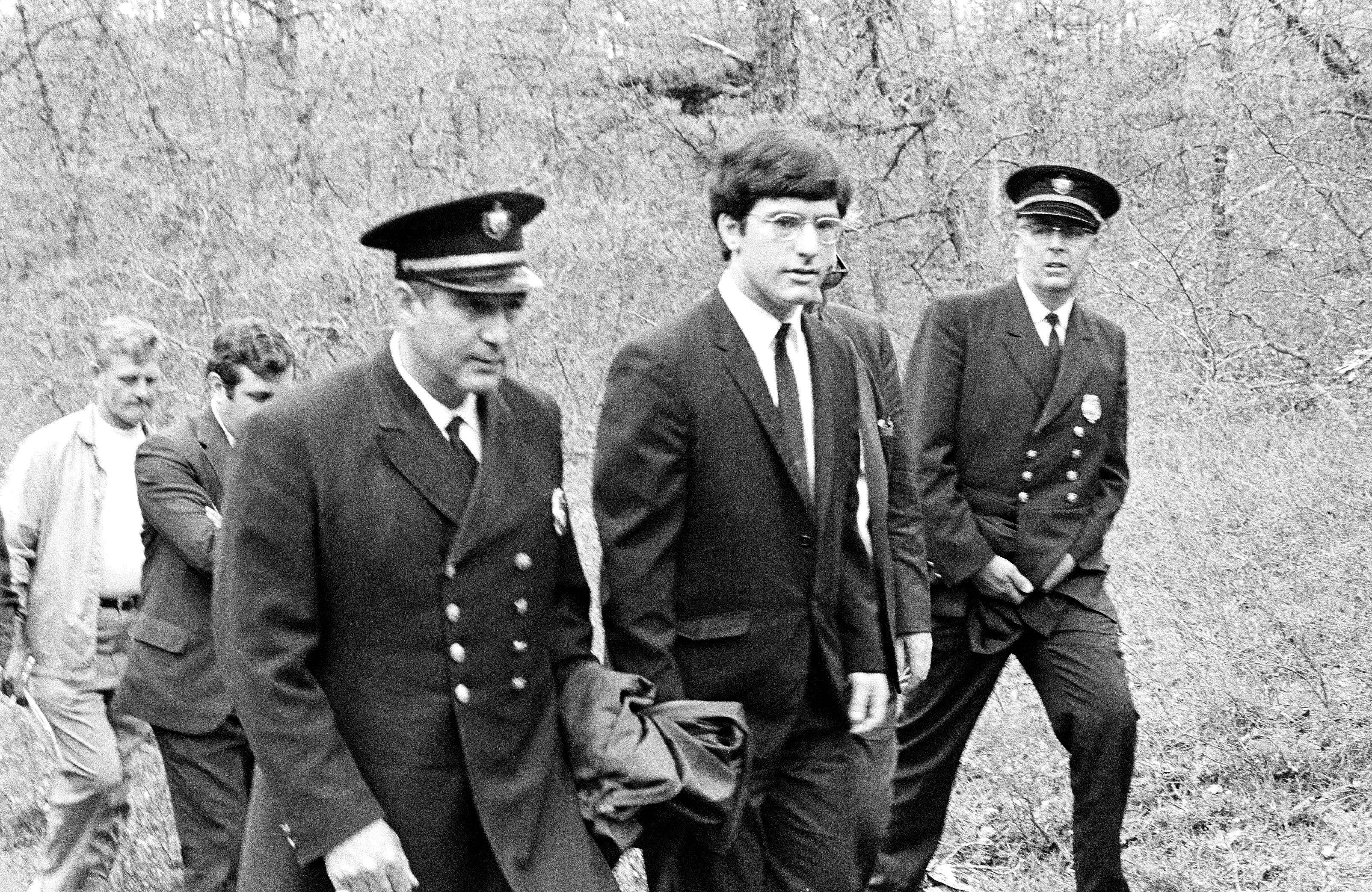 Police accompany Antone ‘Tony’ Costa on 13 May 1970 at the site in Truro, Massachusetts, where the bodies of women he murdered were found