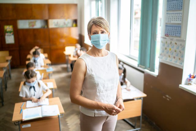 Teacher wears a protective face mask at school