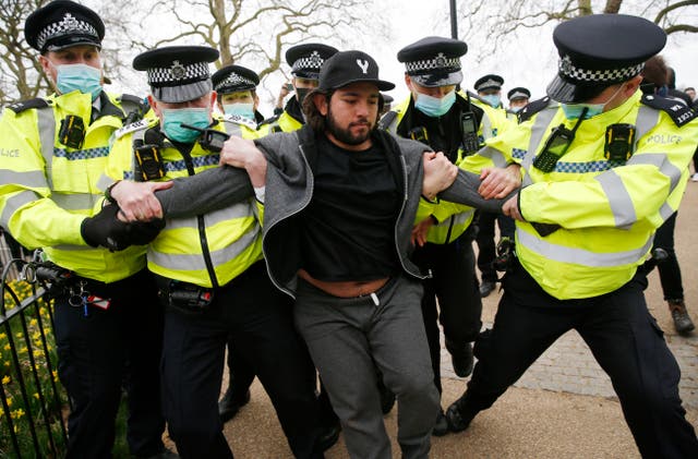 <p>A protester is apprehended by police during the London protest on Saturday</p>