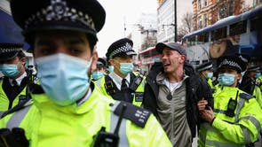 Αστυνομικοί κρατούν έναν διαδηλωτή κατά τη διάρκεια διαμαρτυρίας ενάντια στο κλείδωμα στο Λονδίνο