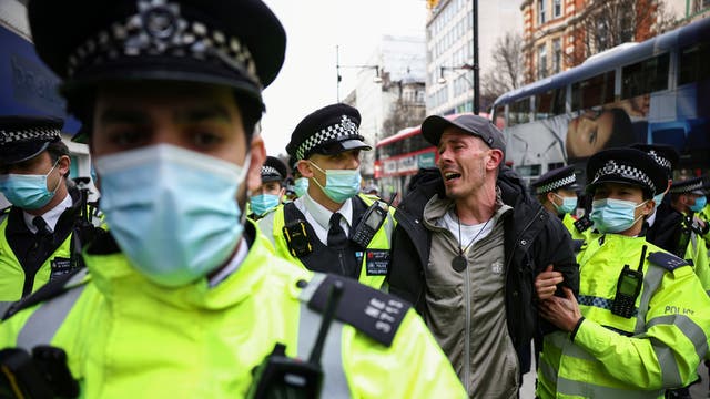 Police officers detain a demonstrator during a protest against the lockdown in London