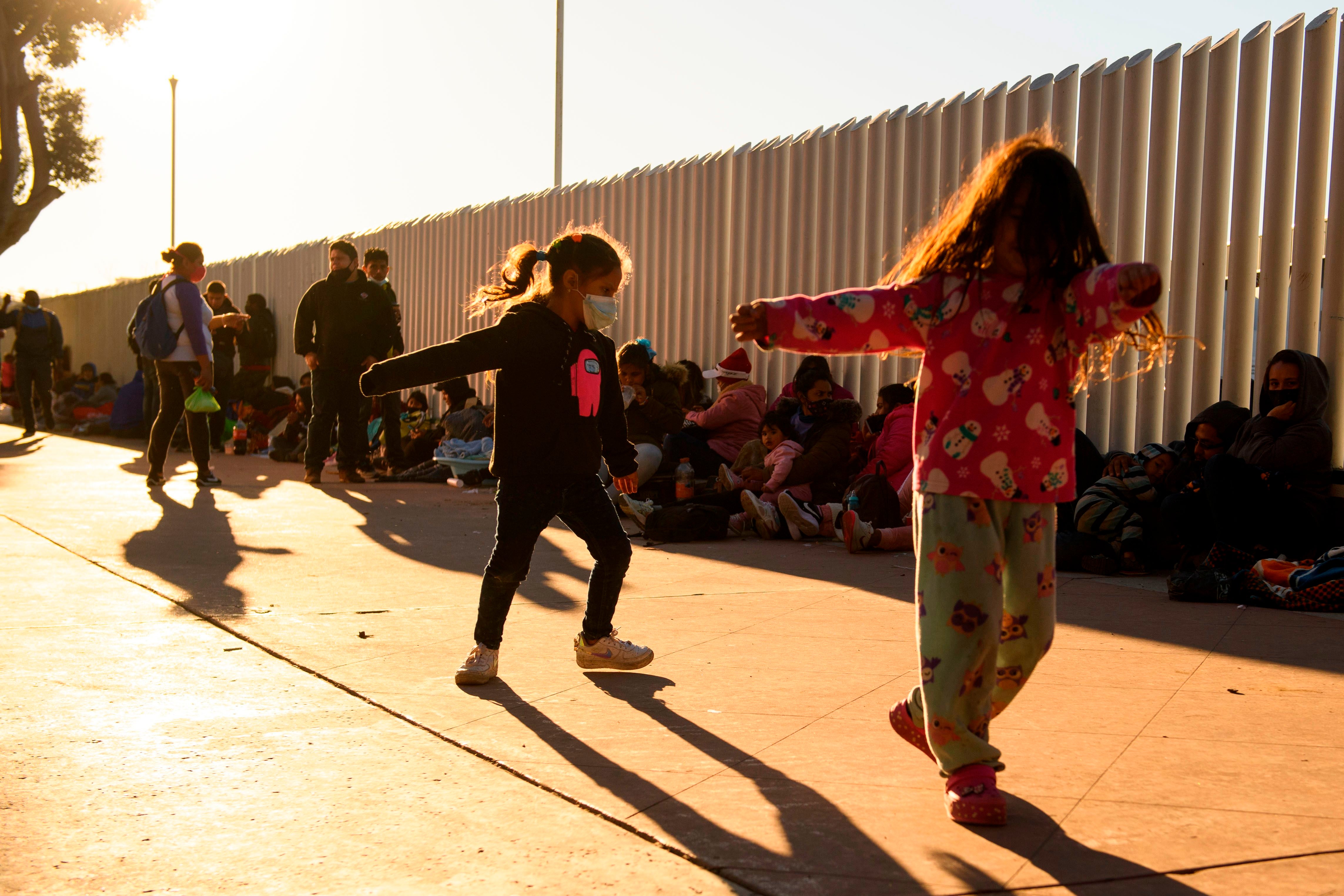 Children play as families of asylum seekers wait outside the El Chaparral border crossing port as they wait to cross into the United States in Tijuana, Baja California state, Mexico