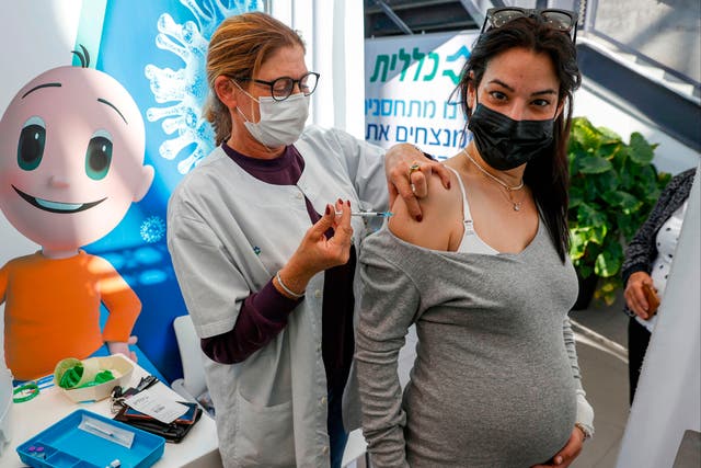 A health worker administers a dose of the Pfizer-BioNtech COVID-19 vaccine to a pregnant woman in Tel Aviv, Israel on 23 January, 2021. 