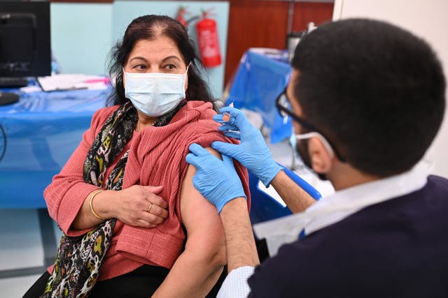 Pharmacist, Minhal Master (R) administers a dose of the AstraZeneca/Oxford Covid-19 vaccine at a temporary vaccination centre, staffed by pharmacists and pharmacist assistants, at the Al-Abbas Islamic Centre in Birmingham, West Midlands