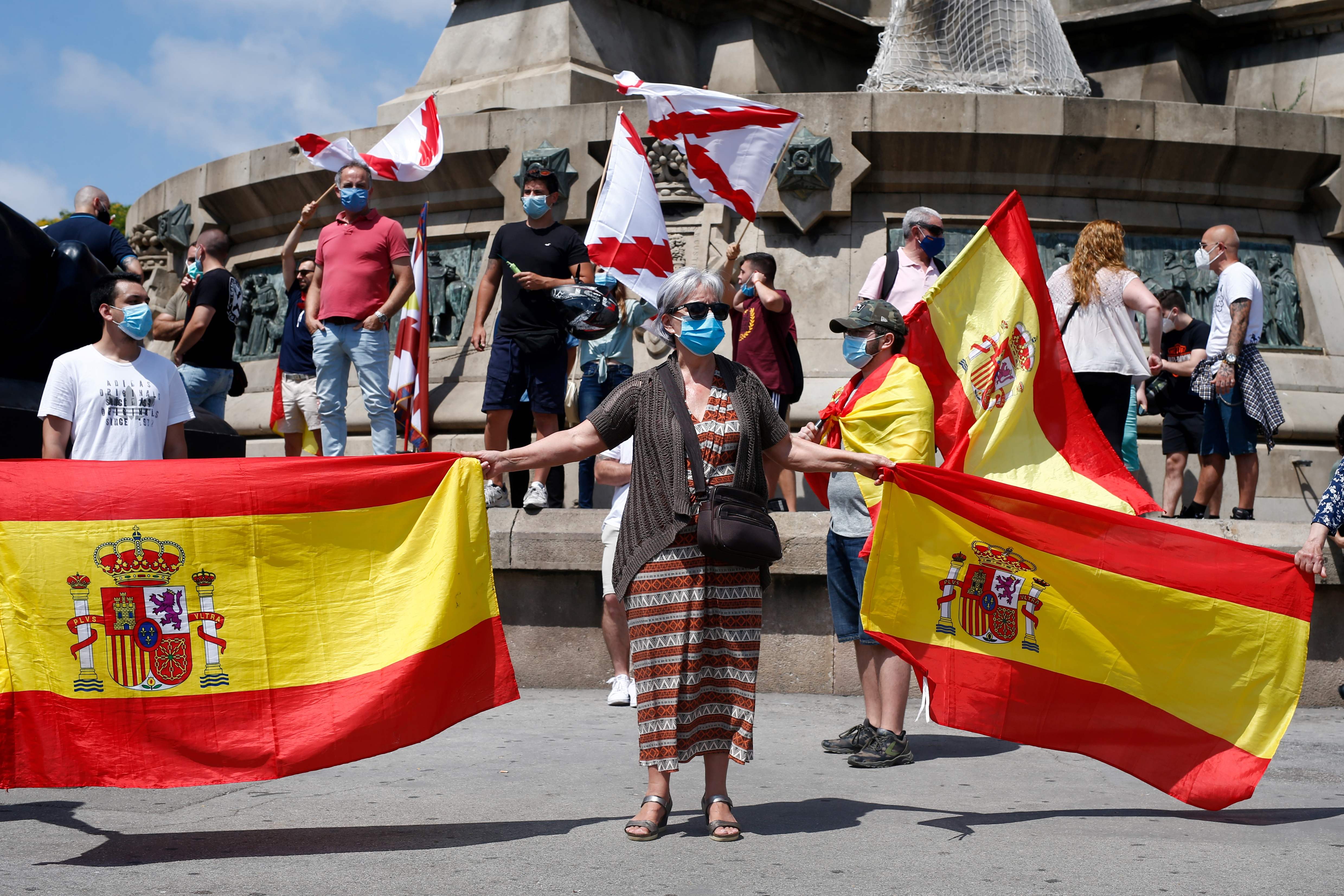 Protesters hold Spanish national flags and Cross of Burgundy flags during a demonstration by Spain's far-Right Vox party to preserve a statue of Christopher Columbus