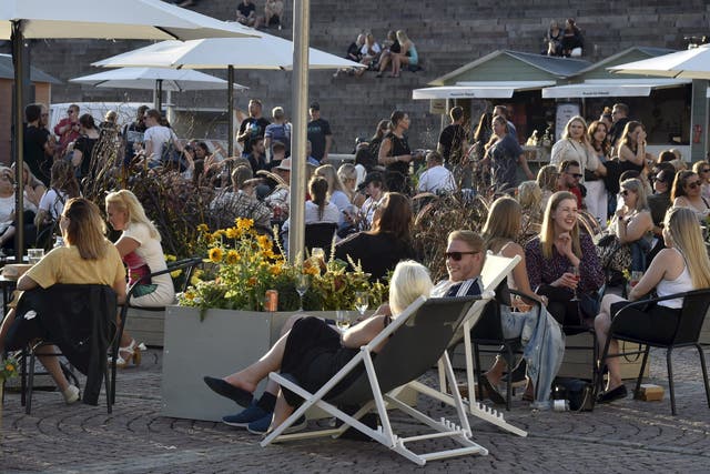 People enjoy meals and drinks on a large open-air food court in the centrally-located Senate Square in Helsinki, Finland, late on  17 July, 2020, the first Friday after a lifting of Covid-19 restrictions.