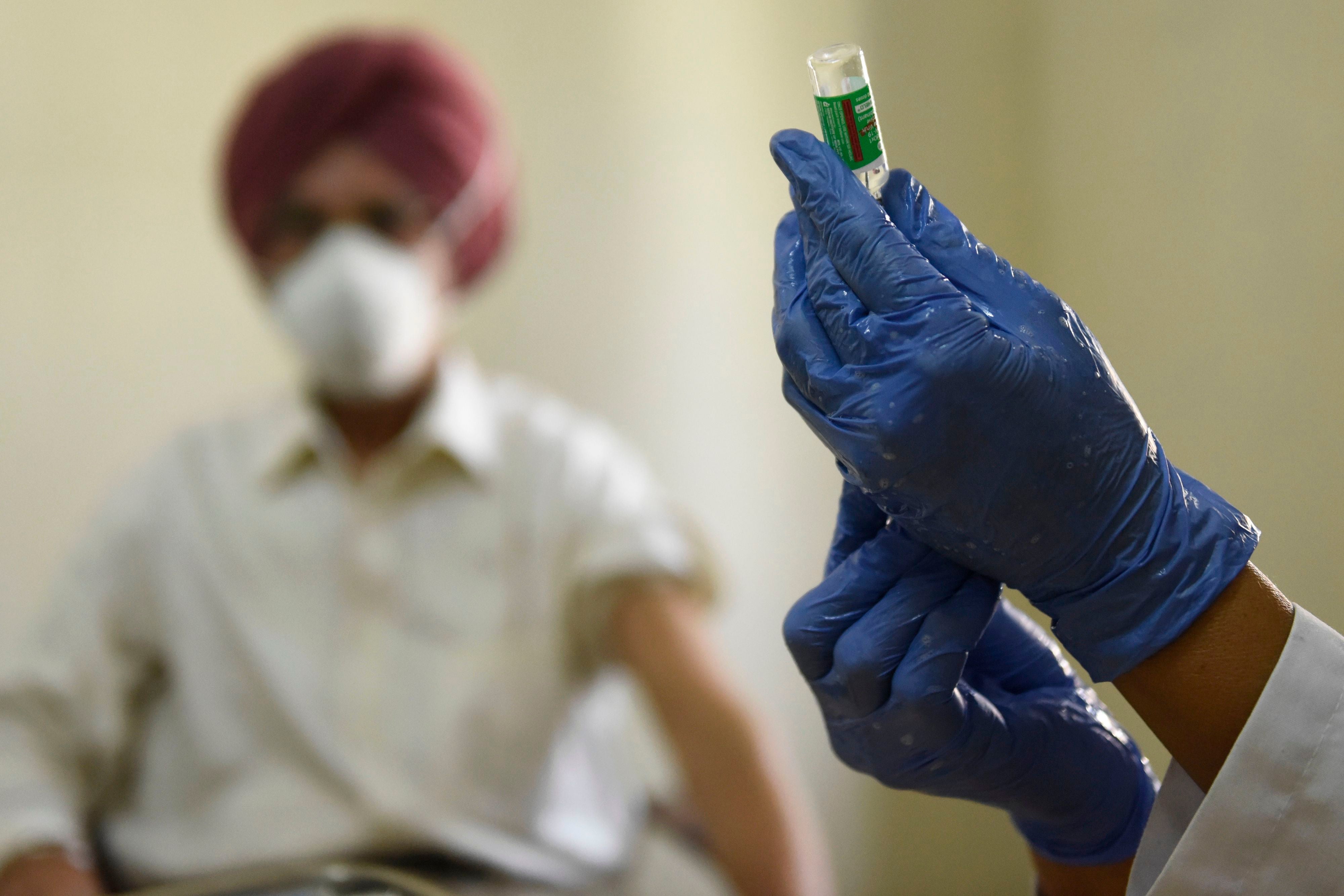 A medical worker prepares to inoculate a man with a Covid-19 vaccine at a hospital in Amritsar on 1 March, 2021