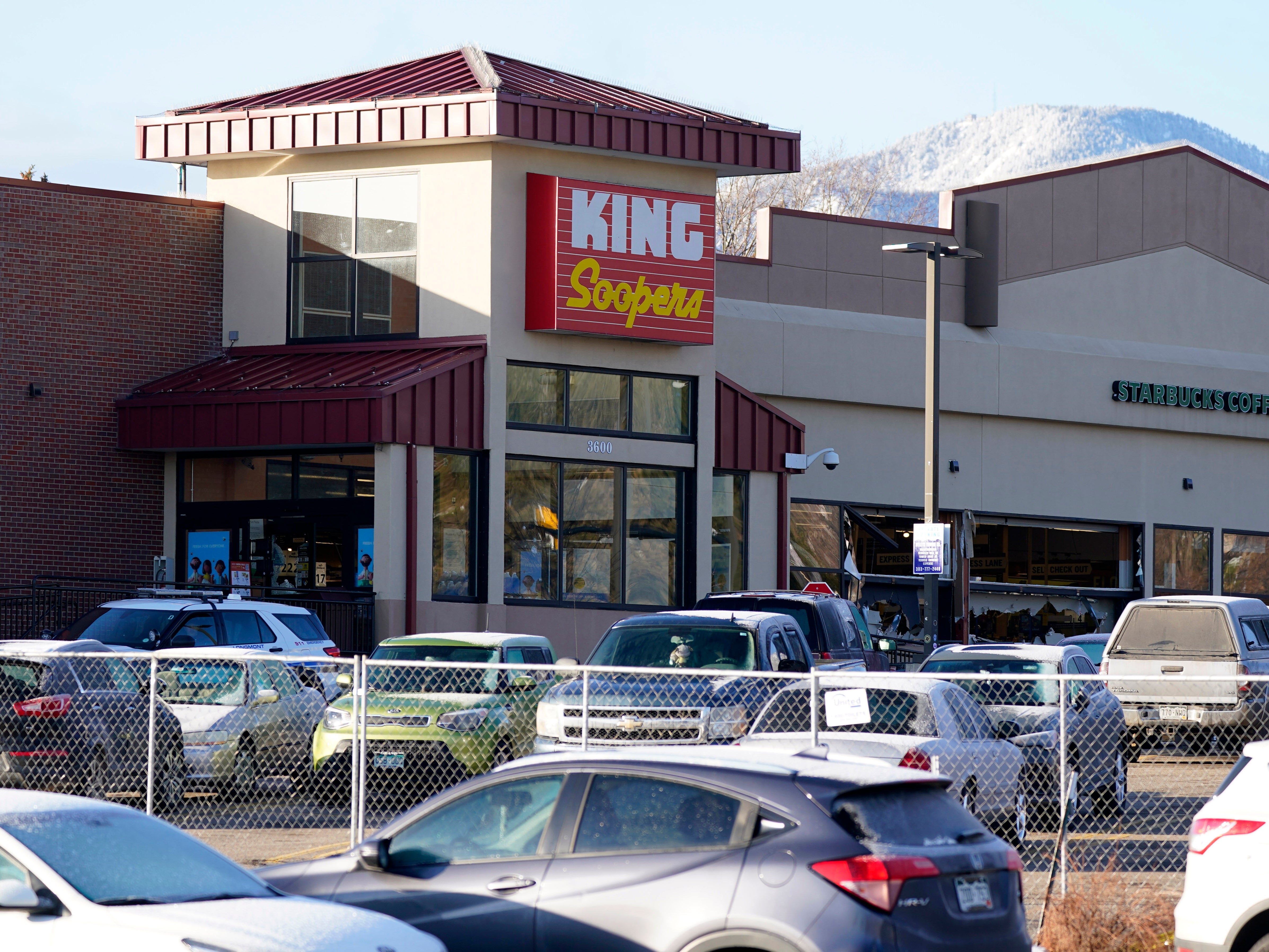A makeshift fence stands around the parking lot outside a King Soopers grocery store where a mass shooting took place a day earlier in Boulder, Colorado