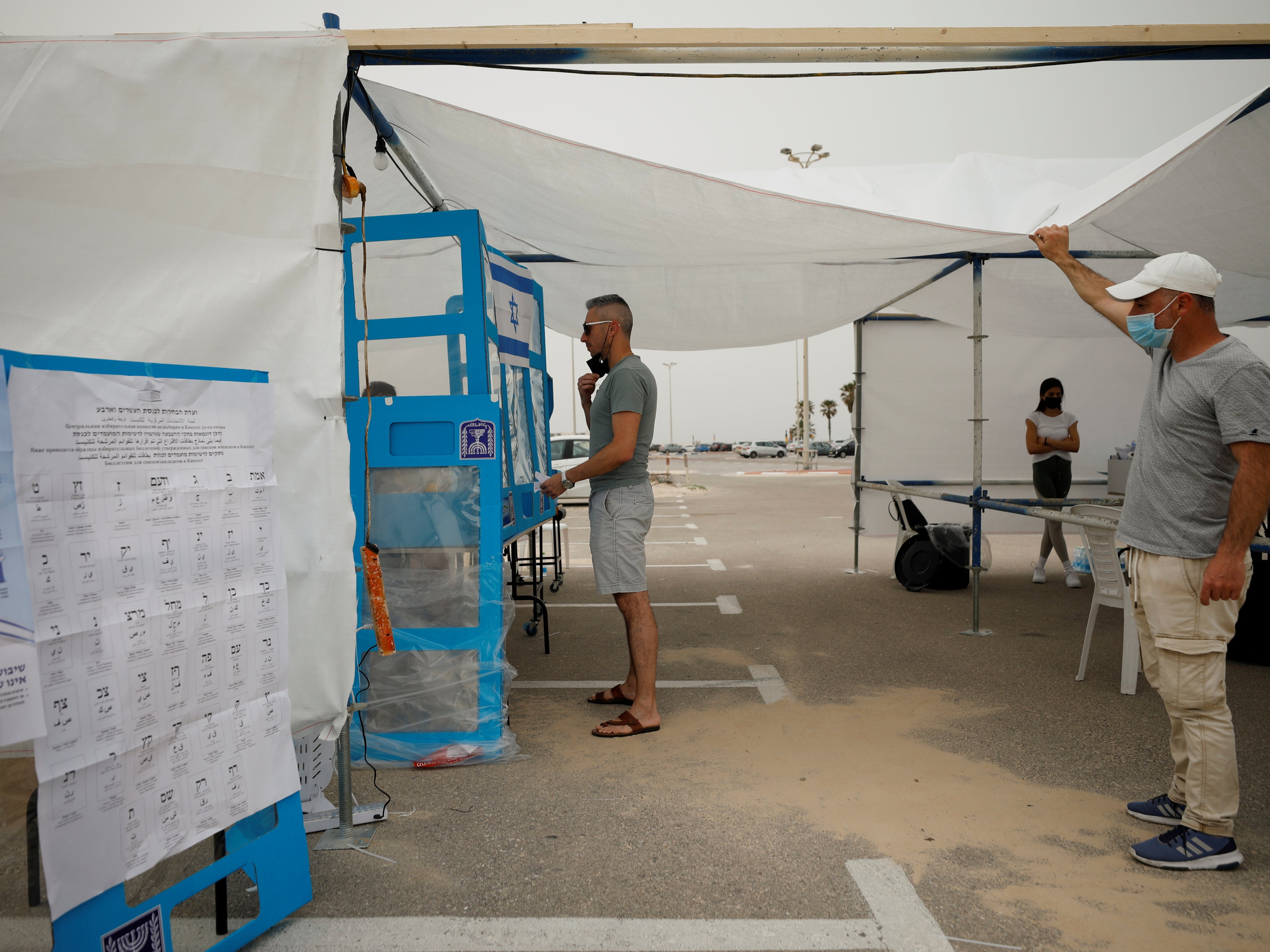 A man prepares to cast his ballot at a special mobile polling station for Israelis in quarantine or infected with the coronavirus disease near a beach in Ashdod