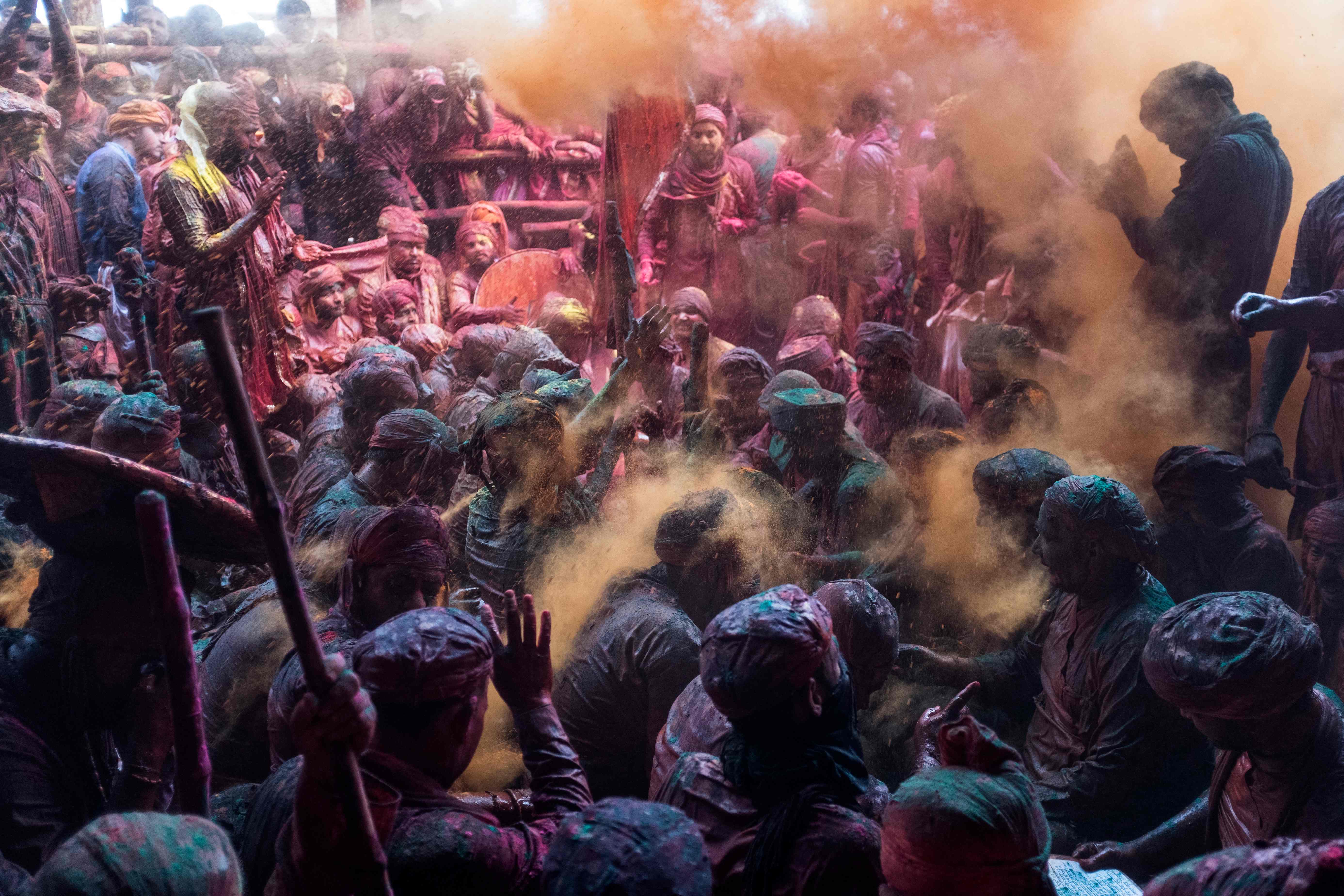 Coloured powder is thrown over Hindu devotees in a traditional gathering during Holi celebrations, the spring festival of colours, at a temple in Barsana village in Uttar Pradesh, India