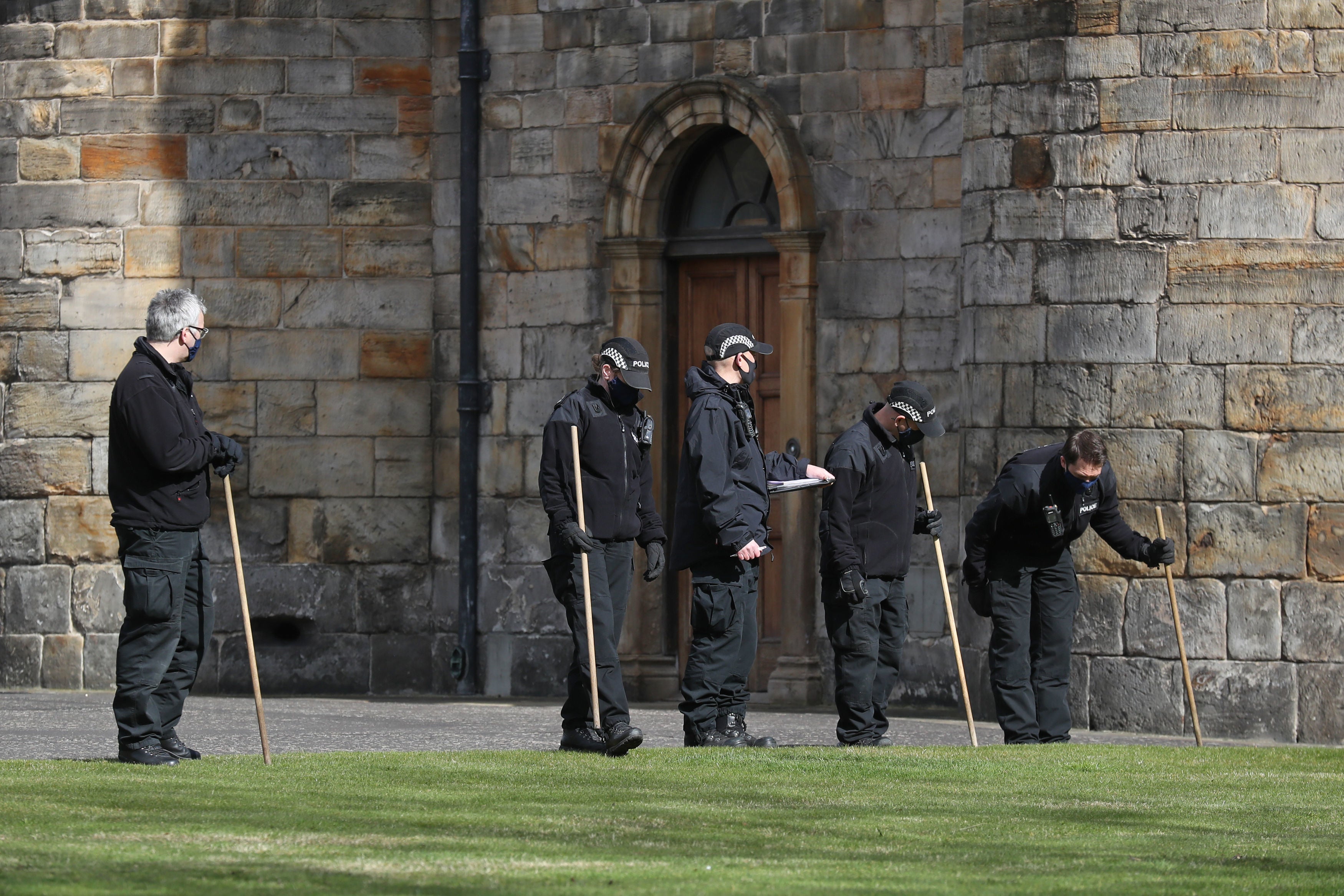 Police officers search within the grounds of the Palace of Holyroodhouse in Edinburgh after a bomb disposal team was called to a ‘suspicious item’ at the Queen’s residence