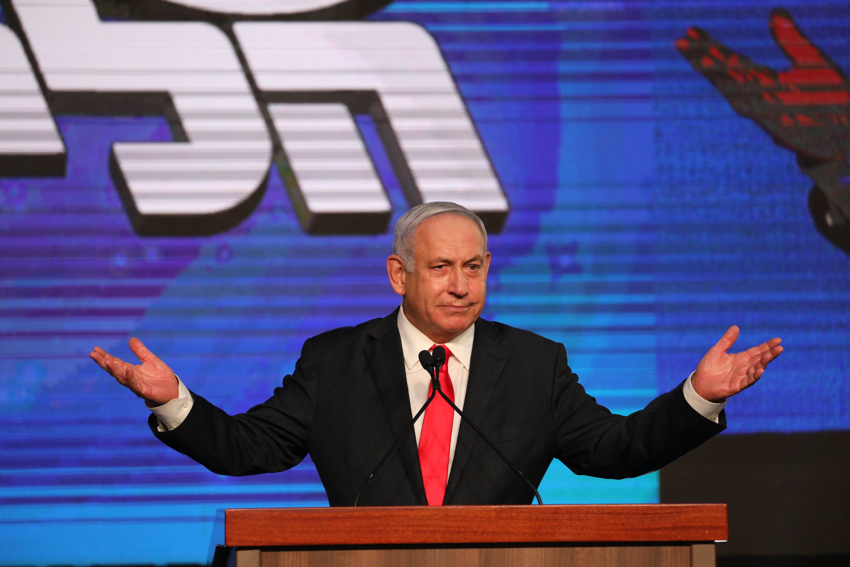 In the balance: Benjamin Netanyahu greets supporters after early exit polls on Wednesday