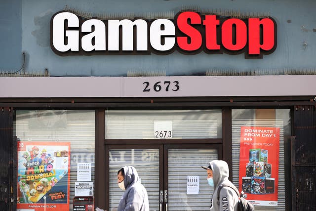<p>Pedestrians walk by a GameStop store on March 10, 2021 in San Francisco, California. </p>