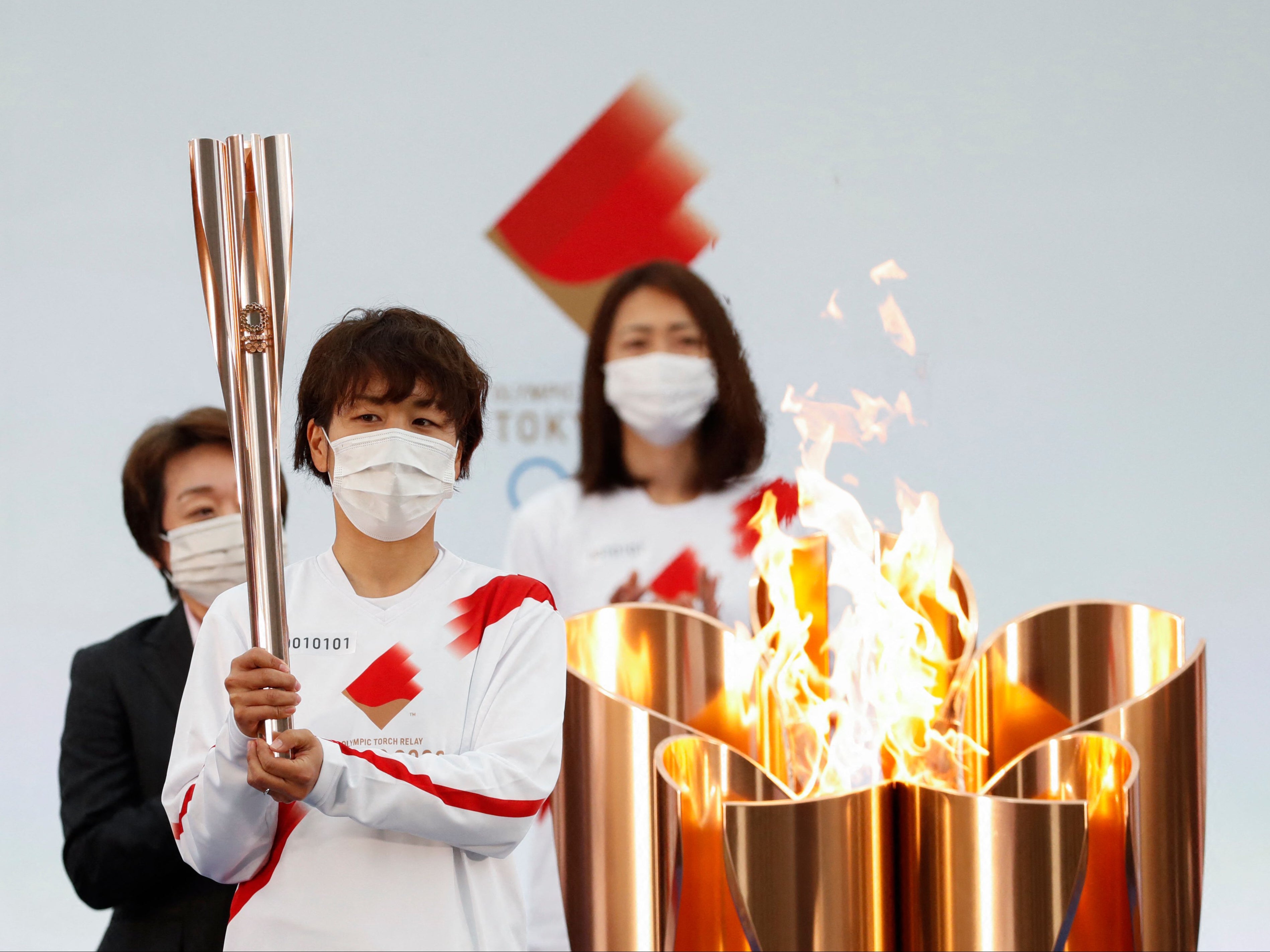 A member of Japan's women's national football team holds the Olympic torch