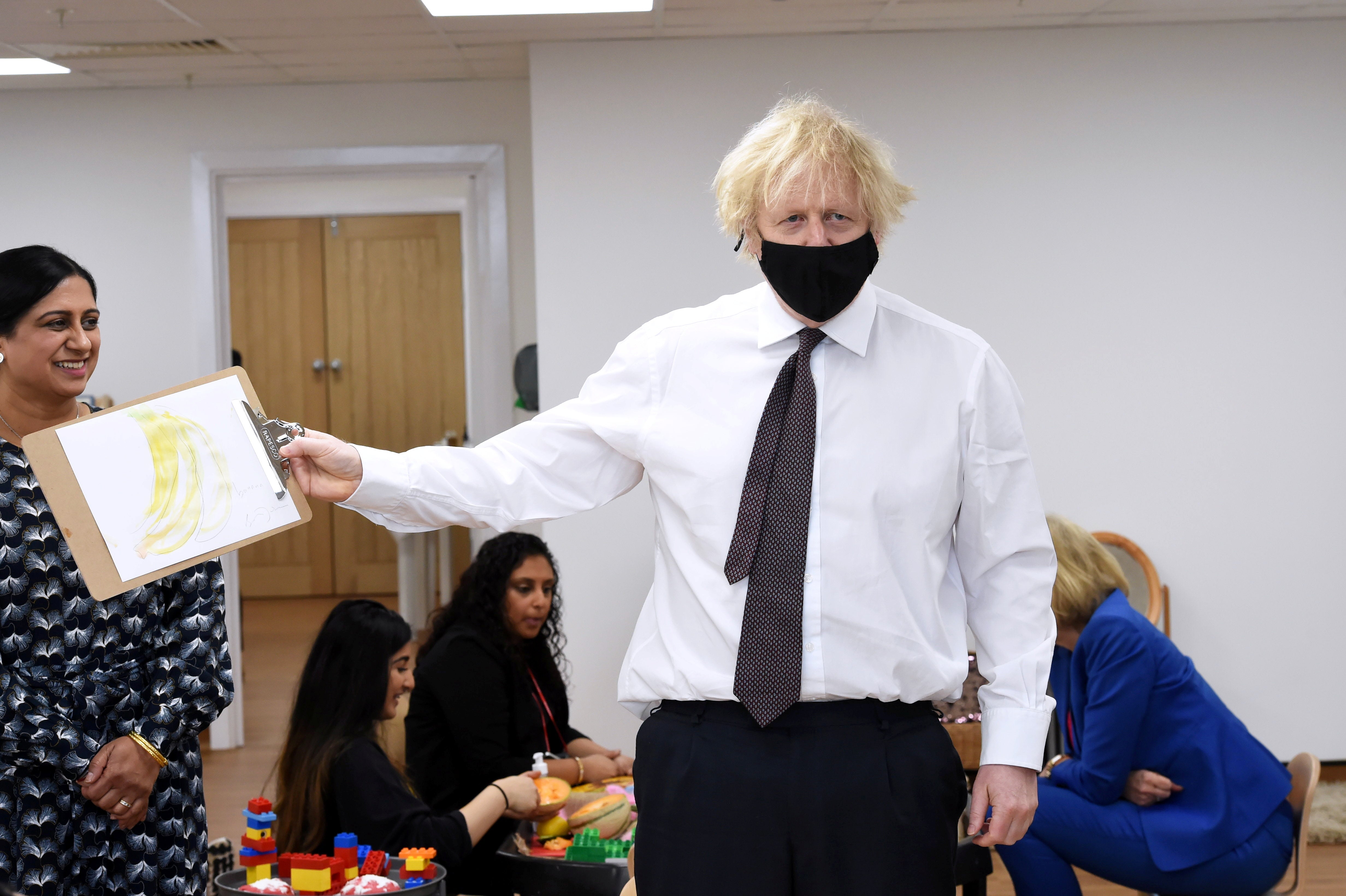 Boris Johnson displays his banana drawing during a visit to Monkey Puzzle Nursery in Greenford, west London, on Thursday