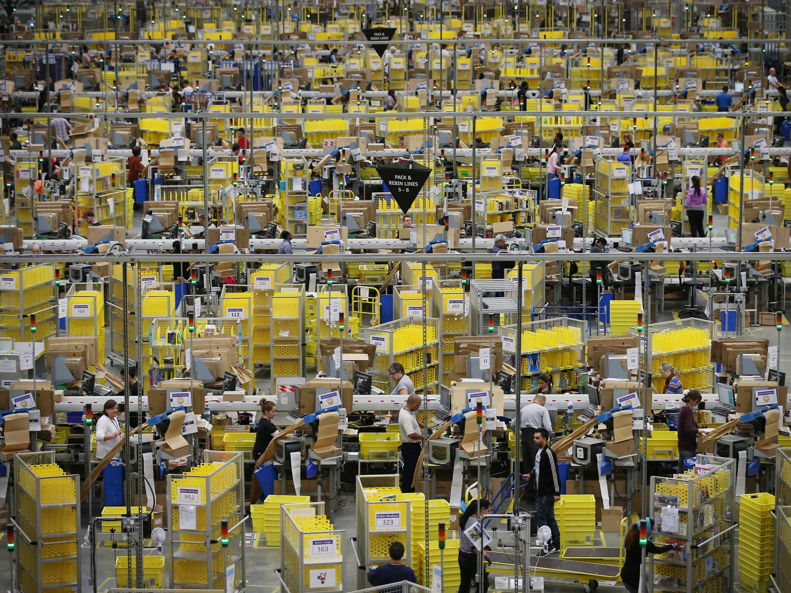 <p>Parcels are prepared for dispatch at Amazon’s warehouse in Hemel Hempstead in 2014</p>