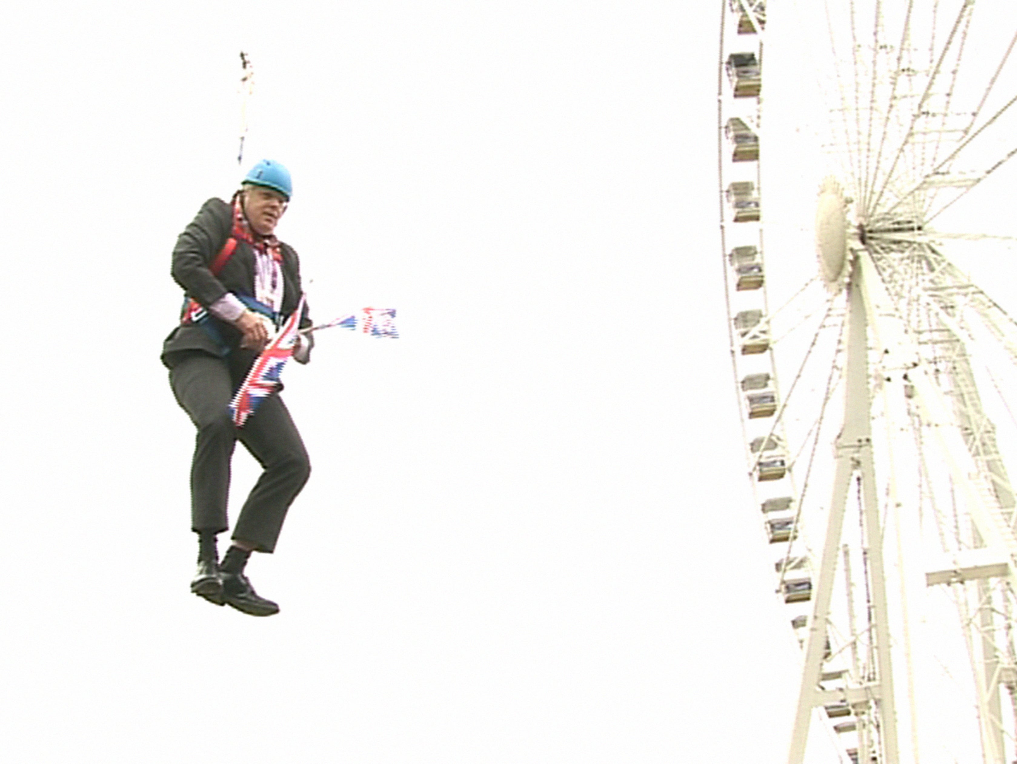 Boris Johnson, the then London mayor, clutches two flags after he was left hanging in mid-air when he got stuck on a zipwire at an Olympic event at Victoria Park