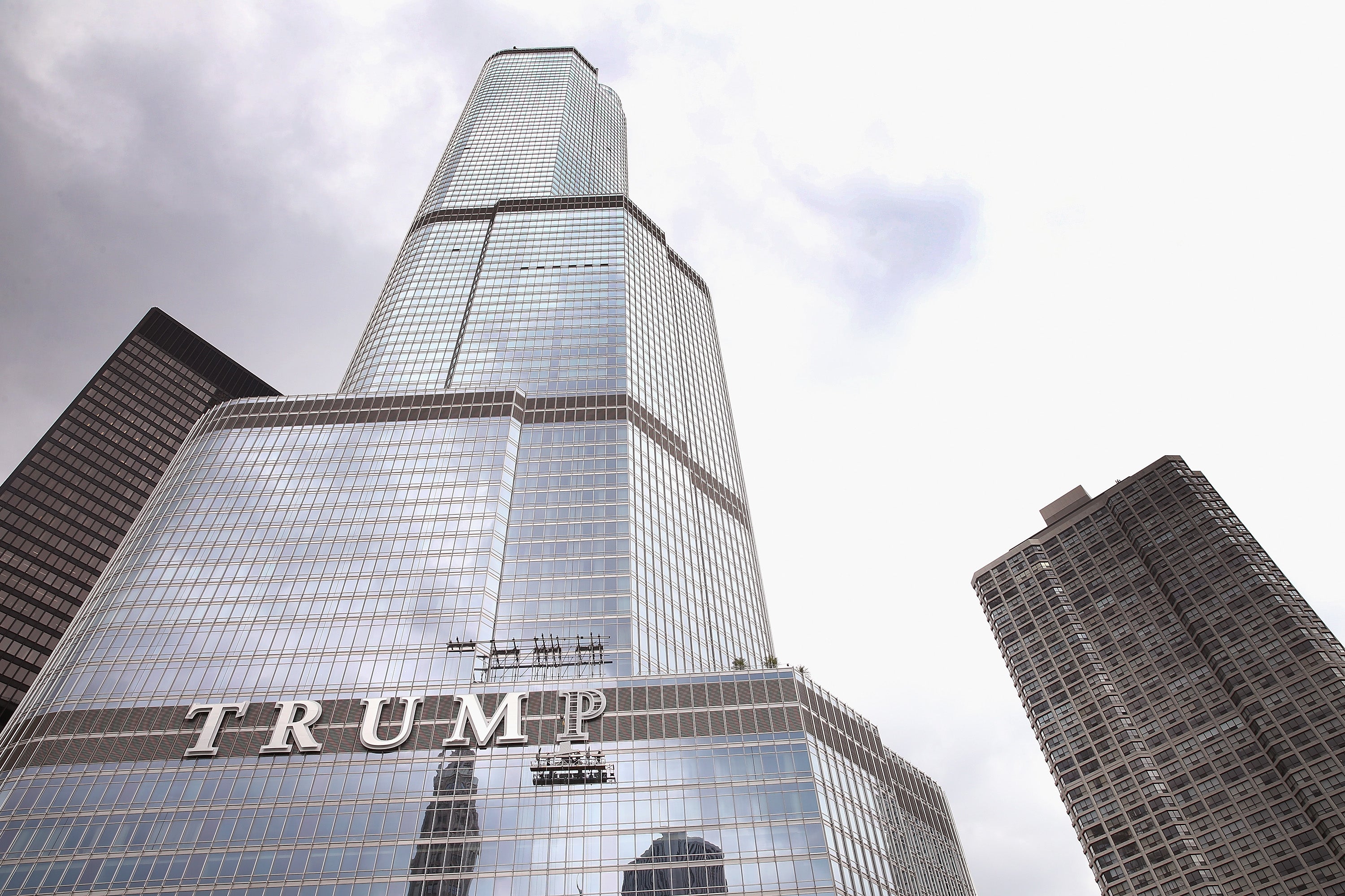 Workers install the final letter for a giant sign on the outside of the Trump Tower in 2014