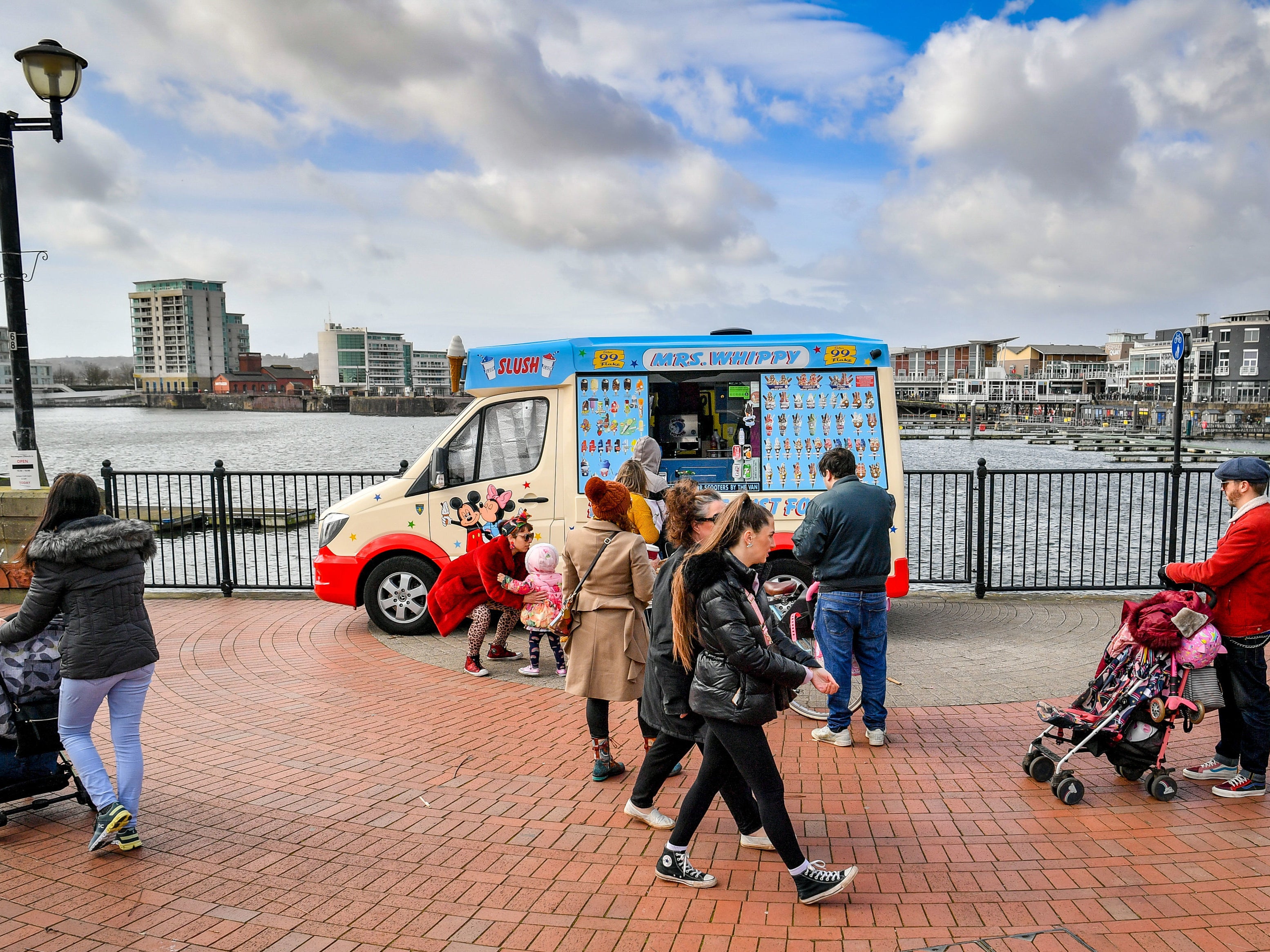 People queue for an ice-cream van in Cardiff Bay, Wales, where stay at home restrictions are eased and people are permitted to travel within their local area, including meeting family and friends who live locally as long as it is outdoors