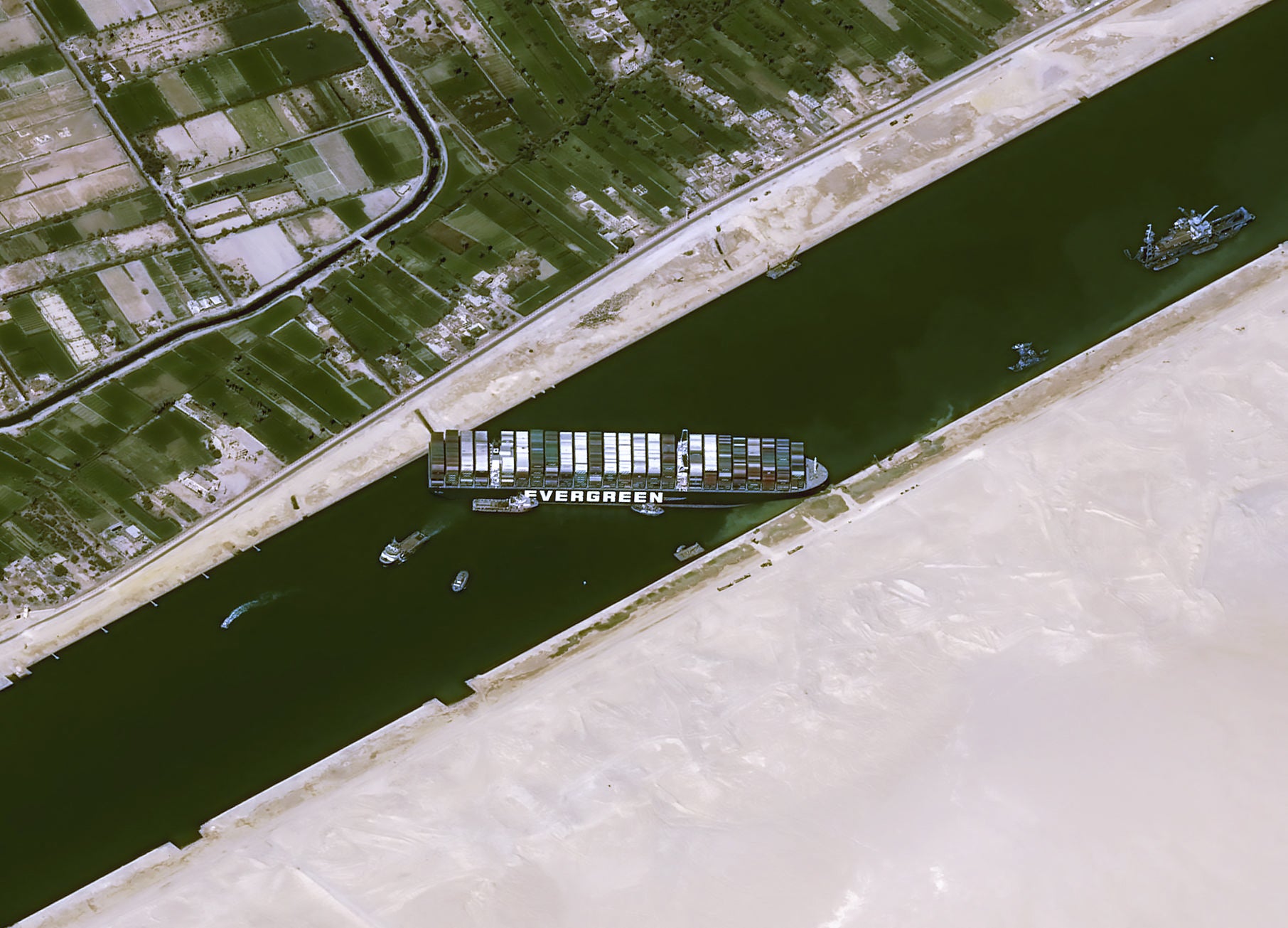 This handout satellite images courtesy of Cnes 2020 released on 25 March 2021 by Airbus DS shows the Taiwan-owned MV 'Ever Given' (Evergreen) container ship, a 400-metre- (1,300-foot-)long and 59-metre wide vessel, lodged sideways and impeding all traffic across the waterway of Egypt's Suez Canal