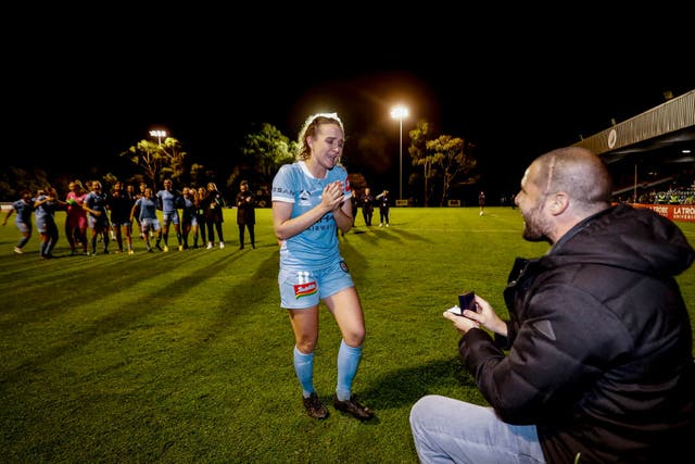 <p>Team-mates watch on as Dobson accepts a proposal</p>