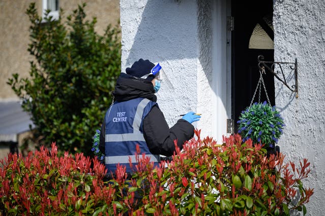 <p> Volunteers deliver Covid-19 test kits to the doors of residents in a specific postcode near Muswell Hill, London on 22 March</p>