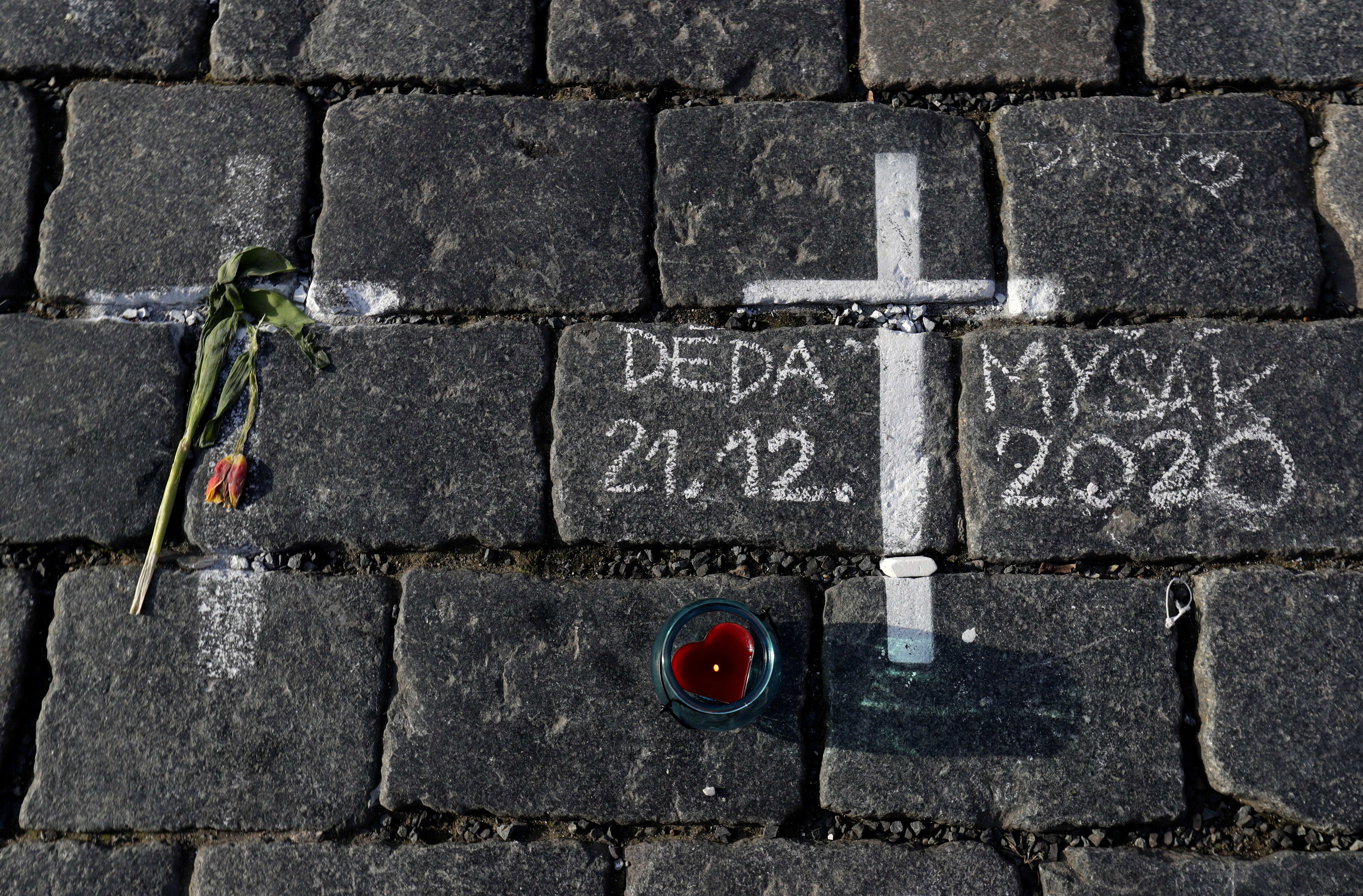 Thousands of crosses have been painted on a pavement in Old Town Square to commemorate a year since the first Covid death