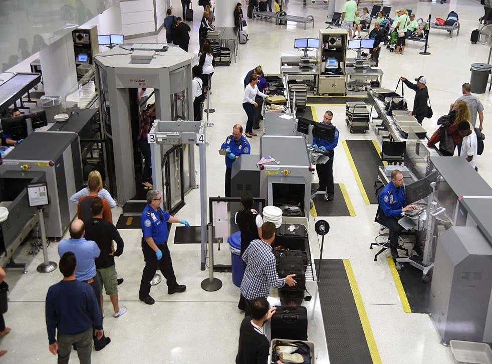 Transportation Security Administration (TSA) officers inspect airline passengers before they board their flights