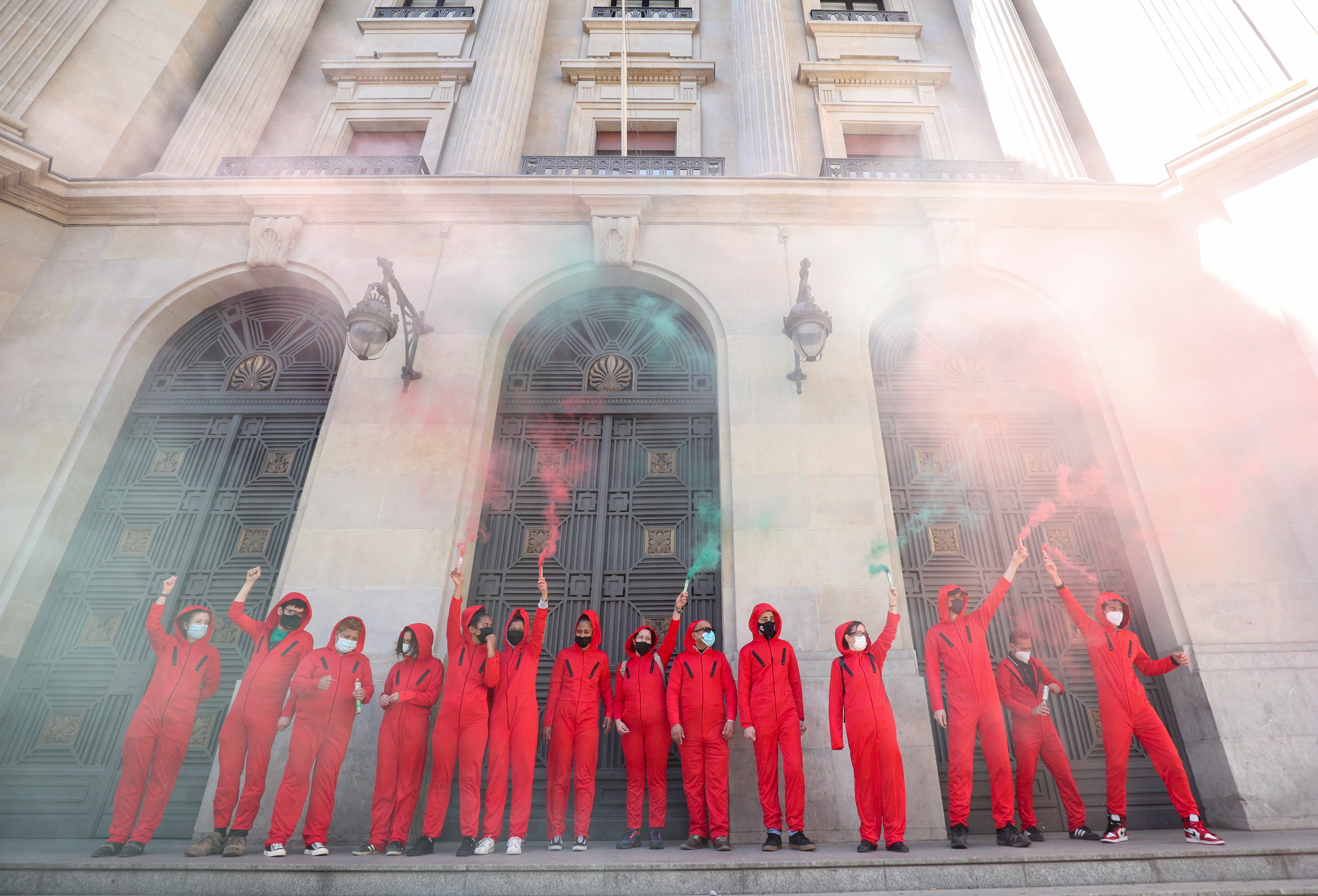 Activists wearing La casa de papel ( Money Heist ) costumes hold smoke flares during a protest in Barcelona in March