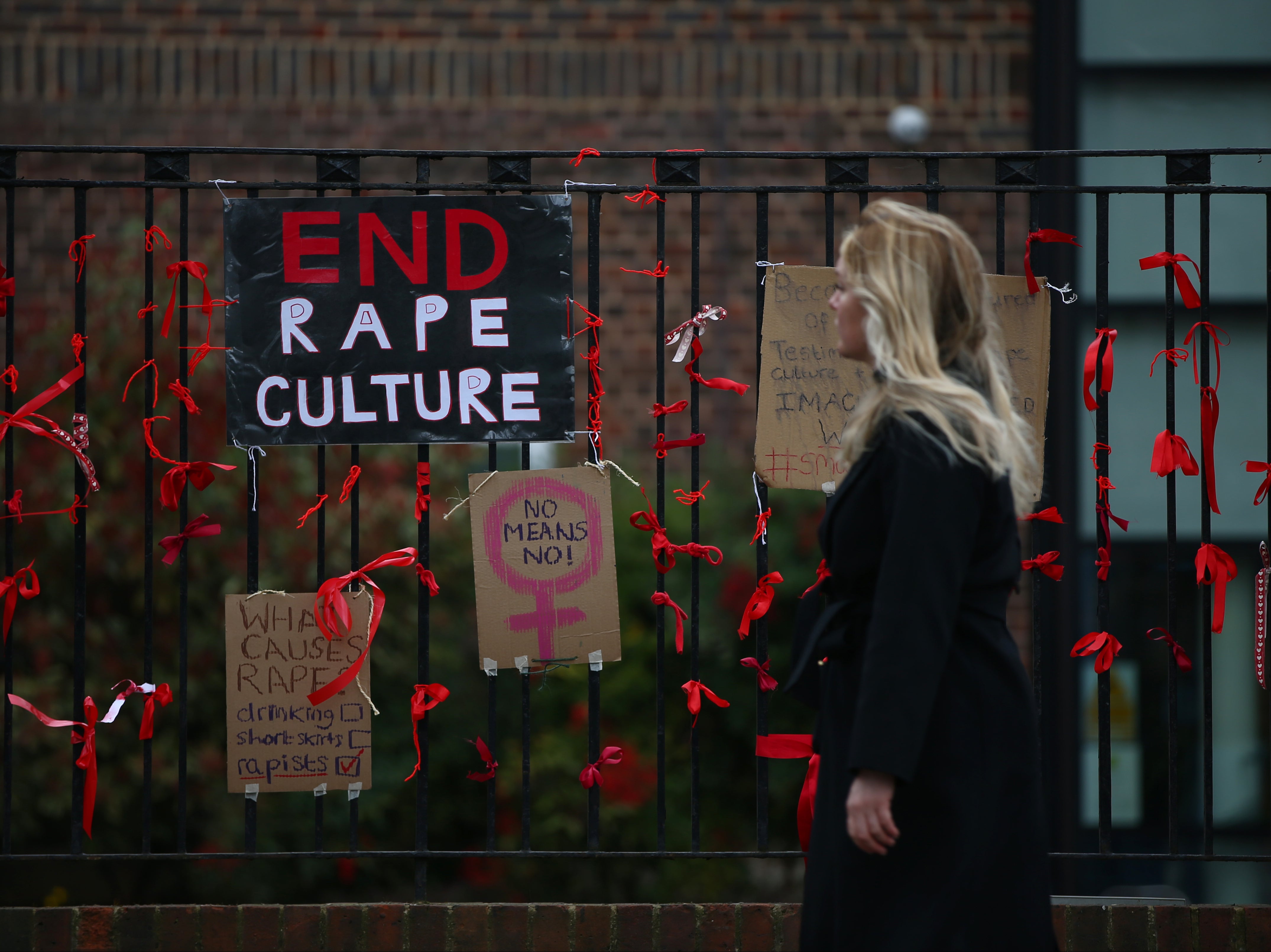 A woman walks past a placard saying ‘End Rape Culture’ outside James Allen’s Girls’ School in south London