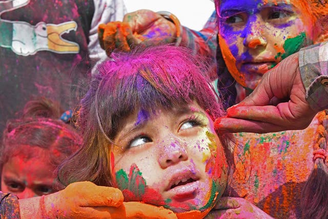 <p>A child is covered in coloured powder during <em>Holi</em> celebrations in Amritsar</p>