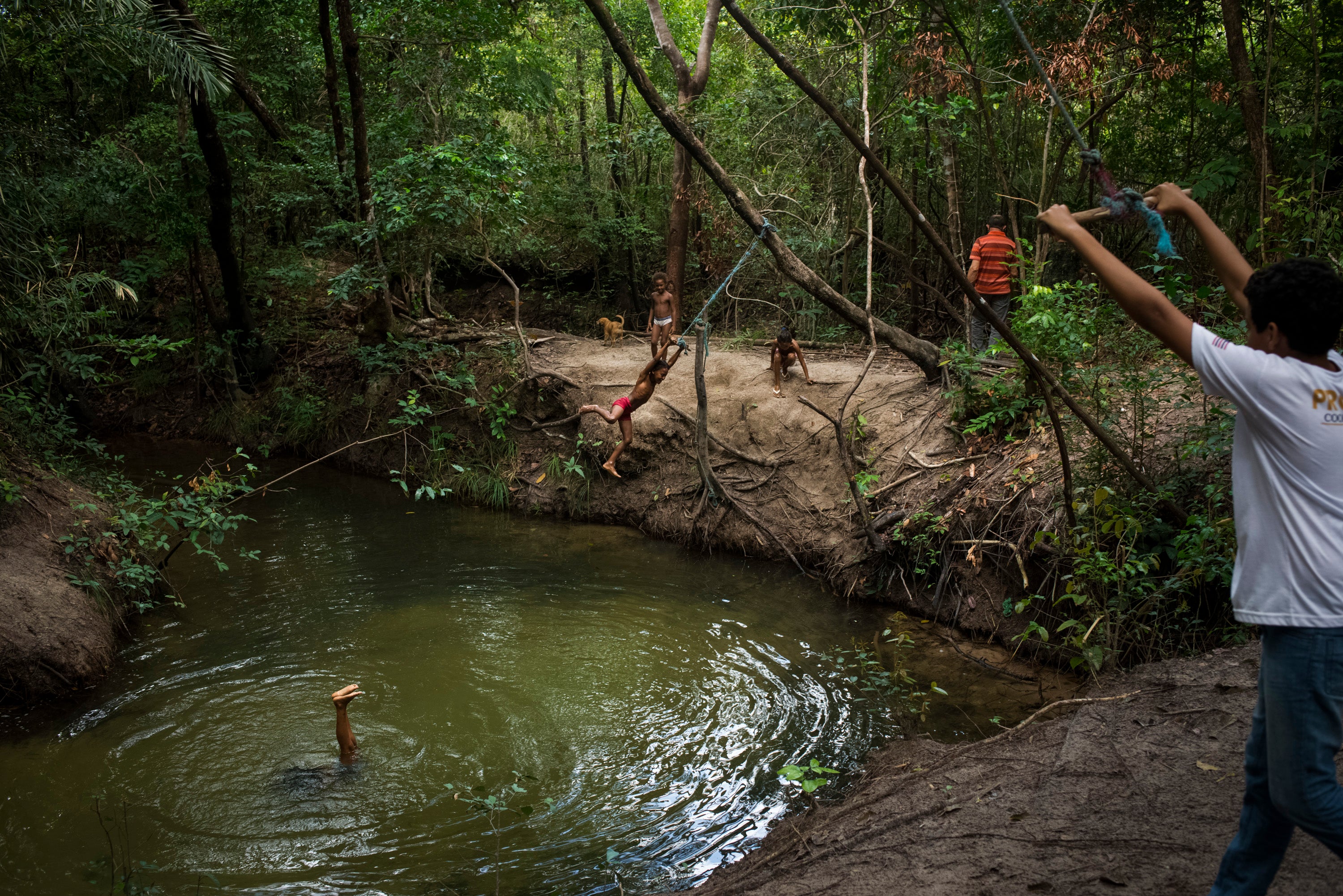 Pinheiro’s relatives play in a river near their home in Alcantara