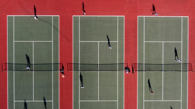  An aerial photo shows people playing tennis at the Mersey Bowman Lawn Tennis Club in Liverpool northwest England on March 29, 2021, as England's third Covid-19 lockdown restrictions ease, allowing groups of up to six people to meet outside. - People in England rushed outside Monday to enjoy sports, picnics and other previously prohibited activities, as the nation entered the second phase of its coronavirus lockdown easing thanks in large part to a successful vaccination drive