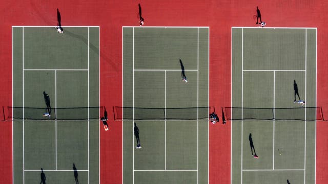An aerial photo shows people playing tennis at the Mersey Bowman Lawn Tennis Club in Liverpool northwest England on March 29, 2021, as England's third Covid-19 lockdown restrictions ease, allowing groups of up to six people to meet outside. - People in England rushed outside Monday to enjoy sports, picnics and other previously prohibited activities, as the nation entered the second phase of its coronavirus lockdown easing thanks in large part to a successful vaccination drive