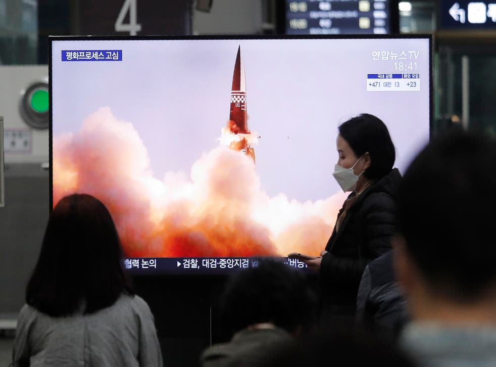 People watch a TV showing an image of North Korea’s new guided missile during a news program at the Suseo Railway Station in Seoul, South Korea, on 26 March 2021